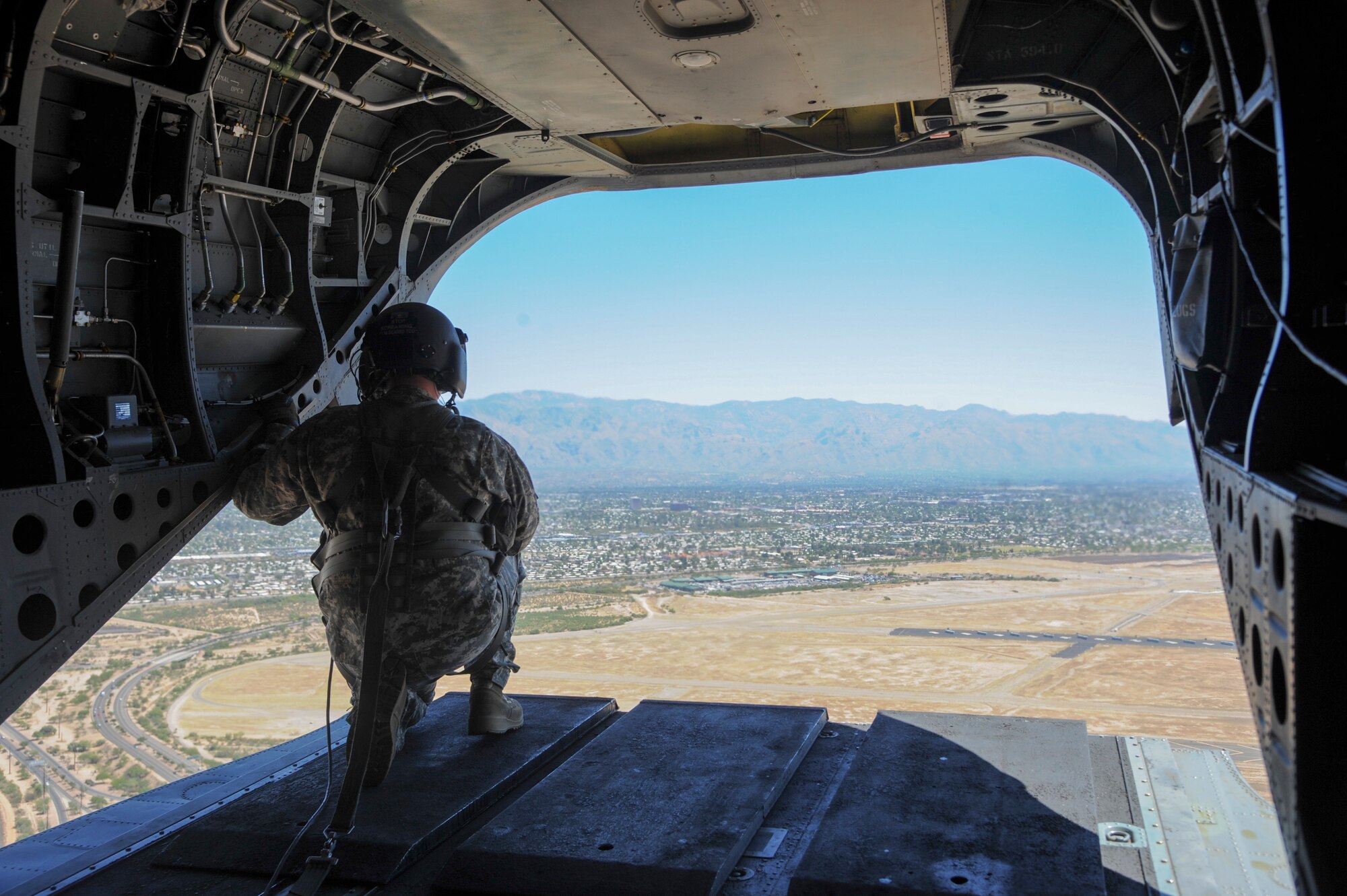 U.S. Army Staff Sgt. Wesley Vincent, Task Force Tatanka, CH-47D Chinook flight engineer, conducts airspace surveillance on the back of a CH-47D during Angel Thunder 2015 over Tucson, Ariz., June 3, 2015. Angel Thunder is the largest personnel recovery exercise in the world combining joint, coalition and interagency personnel. Participants will train through the full spectrum of personnel recovery capabilities with numerous types of aircraft. (U.S. Air Force photo by Senior Airman Betty R. Chevalier/Released)