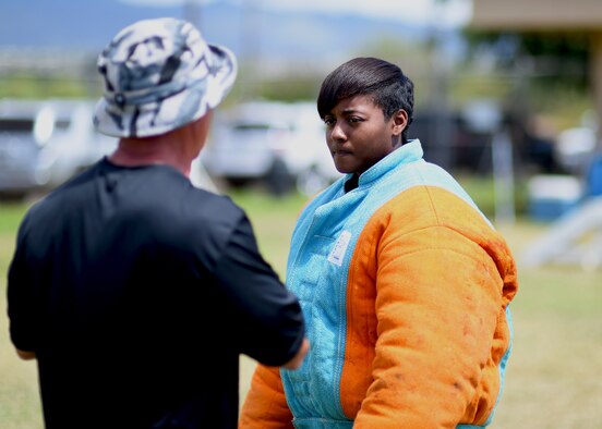 U.S. Navy Master at Arms First Class Maura Johnson, lead petty officer for the Joint Base Pearl Harbor-Hickam, Hawaii, Security Forces Military Working Dog, takes instruction from Fanco Angelini, MWD decoy instructor, during MWD handler decoy training at Ke Kula Maka'i Police Academy, Hawaii, June 3, 2015. The training is a four-day course designed to improve the MWD handlers decoy skills and increase their proficiencies as trainers for the MWD. (U.S. Air Force photo by Tech. Sgt. Aaron Oelrich/Released) 