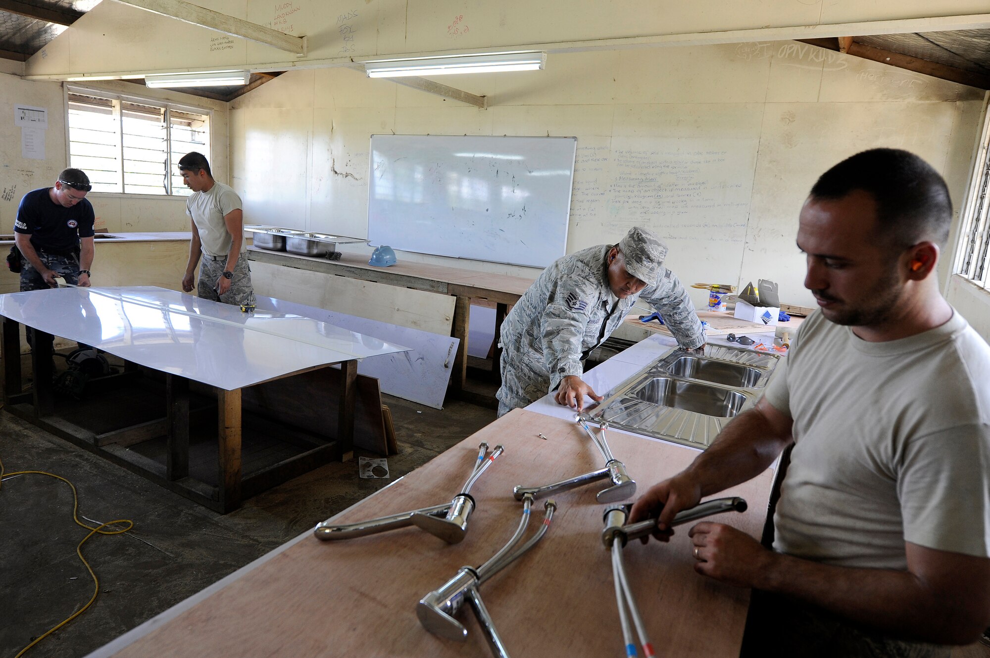 New Zealand Army and U.S. Air Force plumbers and carpenters install sinks and build counters for science lab at Gahuku Primary School in the Eastern Highlands Providence, Papua New Guinea, June 2, 2015. Pacific Angel is a U.S Pacific Command multilateral humanitarian assistance civil military operation, which improves military-to-military partnerships in the Pacific while also providing medical health outreach, civic engineering projects and subject matter exchanges among partner forces. (U.S. Air Force photo by Staff Sgt. Marcus Morris/Released)