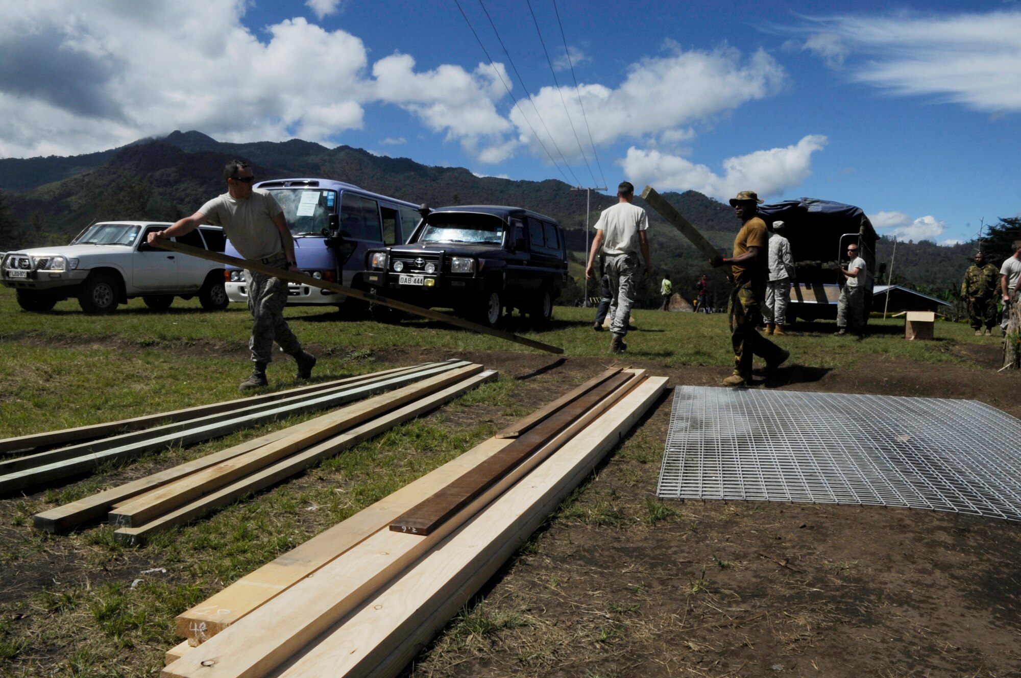 U.S. military, Papua New Guinea Defence Force and New Zealand Army members unload supplies to renovate Gahuku Primary School during Pacific Angel 15-4 in the Eastern Highlands Providence, Papua New Guinea, June 2, 2015. Pacific Angel is a U.S Pacific Command multilateral humanitarian assistance civil military operation, which improves military-to-military partnerships in the Pacific while also providing medical health outreach, civic engineering projects and subject matter exchanges among partner forces. (U.S. Air Force photo by Staff Sgt. Marcus Morris/Released)