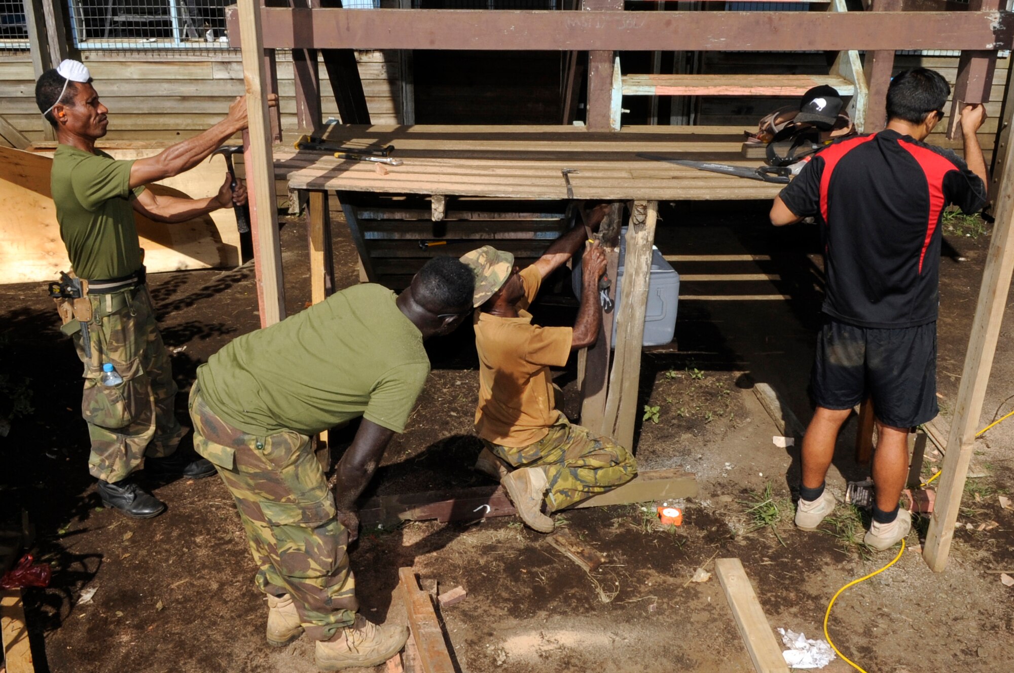 Papua New Guinea Defence Force carpenters and New Zealand Army carpenters repair an unstable staircase during Pacific Angel 15-4 at Gahuku Primary School in the Eastern Highlands Providence, Papua New Guinea, June 2, 2015. Pacific Angel is a U.S Pacific Command multilateral humanitarian assistance civil military operation, which improves military-to-military partnerships in the Pacific while also providing medical health outreach, civic engineering projects and subject matter exchanges among partner forces. (U.S. Air Force photo by Staff Sgt. Marcus Morris/Released)