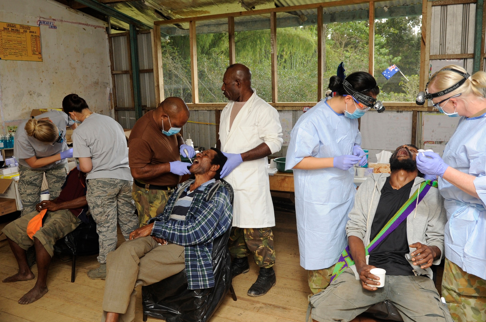 U.S. Air Force, Papua New Guinea Defence Force and Australian Air Force dentists remove broken and rotten teeth for local villagers in urgent need of dental care during Pacific Angel 15-4 at Unggai Primary School in Papua New Guinea, June 1, 2015. The dental team removed more than 350 teeth in three days of health services at the site. Pacific Angel is a U.S Pacific Command multilateral humanitarian assistance civil military operation, which improves military-to-military partnerships in the Pacific while also providing medical health outreach, civic engineering projects and subject matter exchanges among partner forces. (U.S. Air Force photo by Staff Sgt. Marcus Morris/Released)