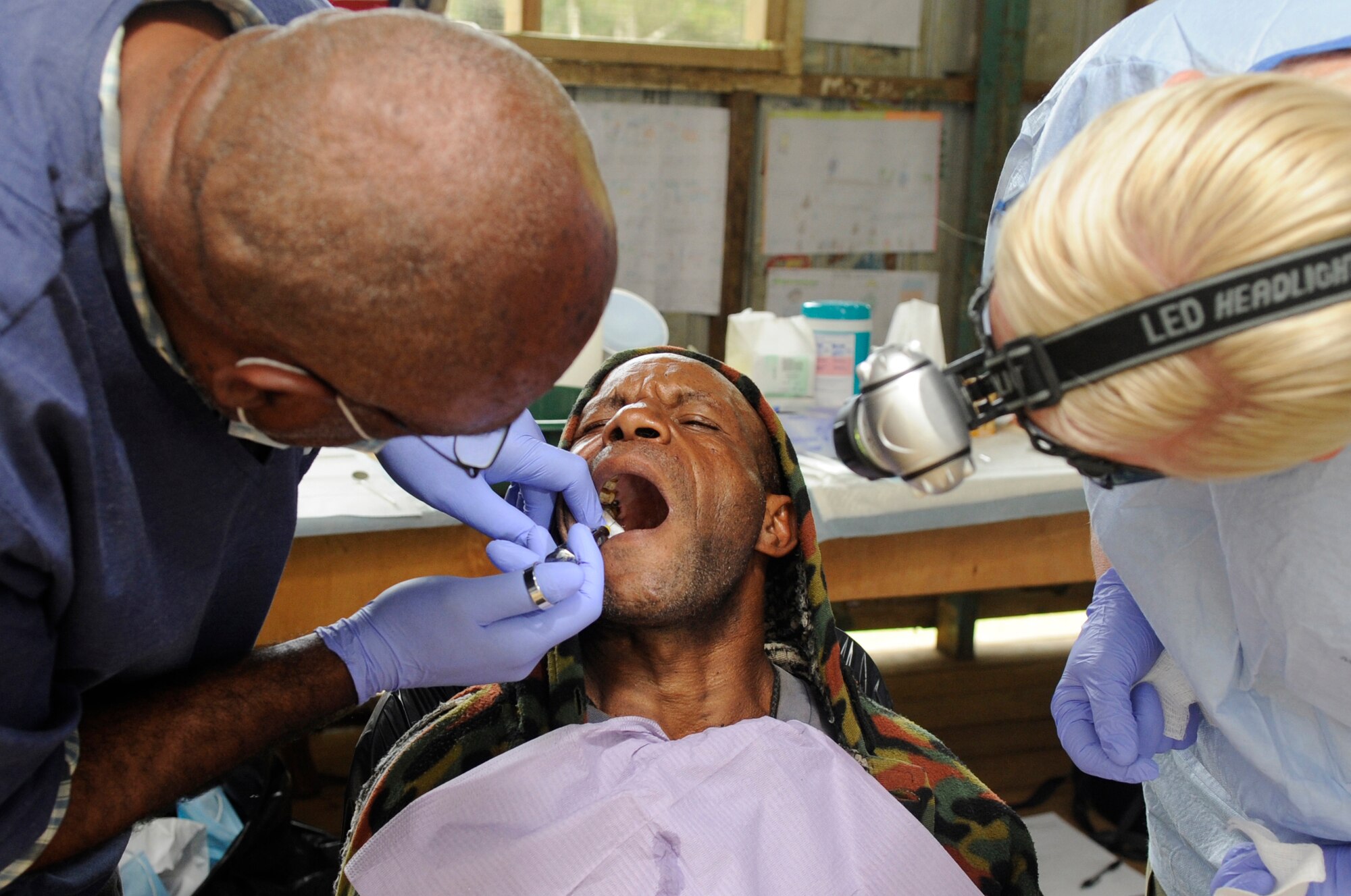 A local Papua New Guinea health services dentist numbs a patient???s mouth to remove a rotten tooth as an Australian Air Force dental technician assists him during Pacific Angel 15-4 at Unggai Primary School in Papua New Guinea, June 1, 2015. Pacific Angel is a U.S Pacific Command multilateral humanitarian assistance civil military operation, which improves military-to-military partnerships in the Pacific while also providing medical health outreach, civic engineering projects and subject matter exchanges among partner forces. (U.S. Air Force photo by Staff Sgt. Marcus Morris/Released)