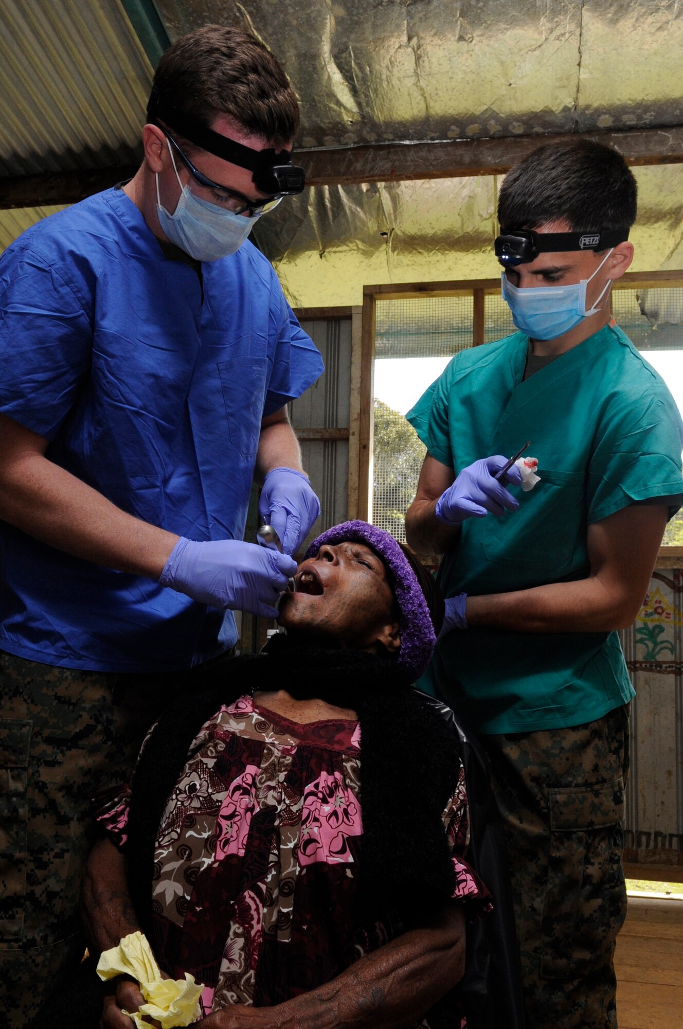 U.S. Navy Lt. John Greiner, from Camp Pendleton, California, 1st Dental Battalion general dentist, removes a broken tooth from a local???s mouth, while Navy Hospital Corpsman 3rd Class Jason Lesieur, 1st Dental Battalion dental technician assists him during Pacific Angel 15-4 at Unggai Primary School in Papua New Guinea, June 1, 2015. Pacific Angel is an annual joint humanitarian assistance mission that is designed to bring humanitarian civic assistance and combined civil-military operations to the Pacific region. (U.S. Air Force photo by Staff Sgt. Marcus Morris/Released)