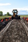 Master Sgt. Ronald Hertz, 341st Civil Engineer Squadron pavement and equipment, operates a grader to allow access to a road for a helicopter tactical slide area project June 3, 2015, at Malmstrom Air Force Base, Mont. The helicopter tactical slide area construction will create an area for the 40th Helicopter Squadron to practice skid landings in the event of an emergency. (U.S. Air Force photo/Chris Willis)
