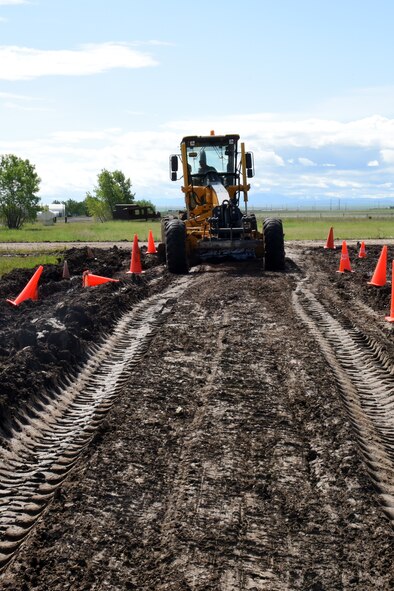 Master Sgt. Ronald Hertz, 341st Civil Engineer Squadron pavement and equipment, operates a grader to allow access to a road for a helicopter tactical slide area project June 3, 2015, at Malmstrom Air Force Base, Mont. The helicopter tactical slide area construction will create an area for the 40th Helicopter Squadron to practice skid landings in the event of an emergency. (U.S. Air Force photo/Chris Willis)