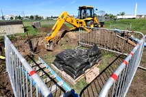 Senior Airman Christopher Moreland, 341st Civil Engineer Squadron pavement and equipment, operates a backhoe during a water valve replacement excavation June 3, 2015, at Malmstrom Air Force Base, Mont. Valve replacement prevents ruptures that could waste the water supply for the entire base. (U.S. Air Force photo/Chris Willis)