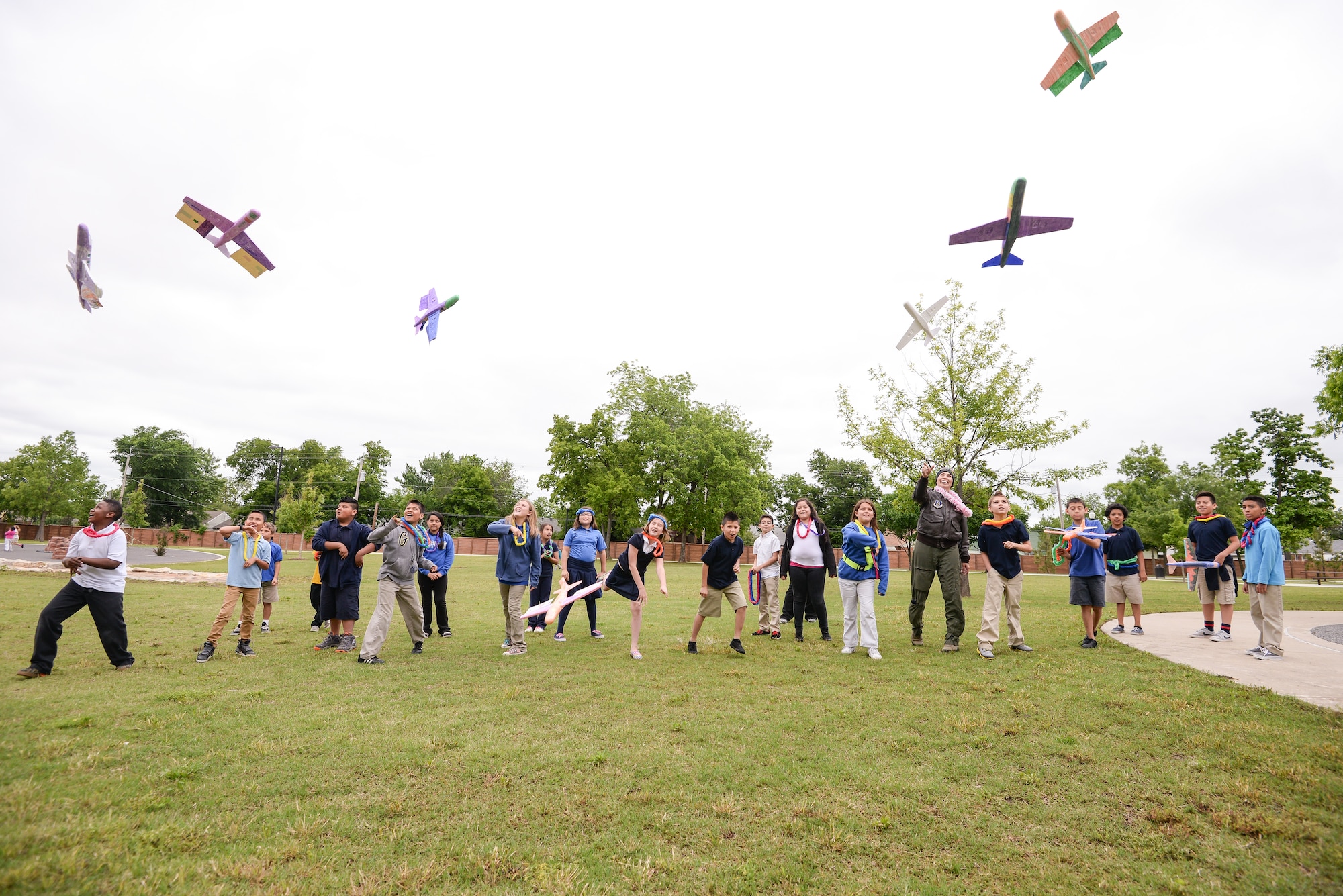Maj. Donna Mae Williams, a pilot assigned to the 465th Air Refueling Squadron at Tinker Air Force Base, Okla., throws Styrofoam airplanes with 4th grade students from Kendall-Whittier Elementary School on May 20 in Tulsa, Okla. Williams visited the students after corresponding with them about her battle with cancer and career as a pilot in the Air Force Reserve. (Air Force photo by Staff Sgt. Caleb Wanzer/Released)