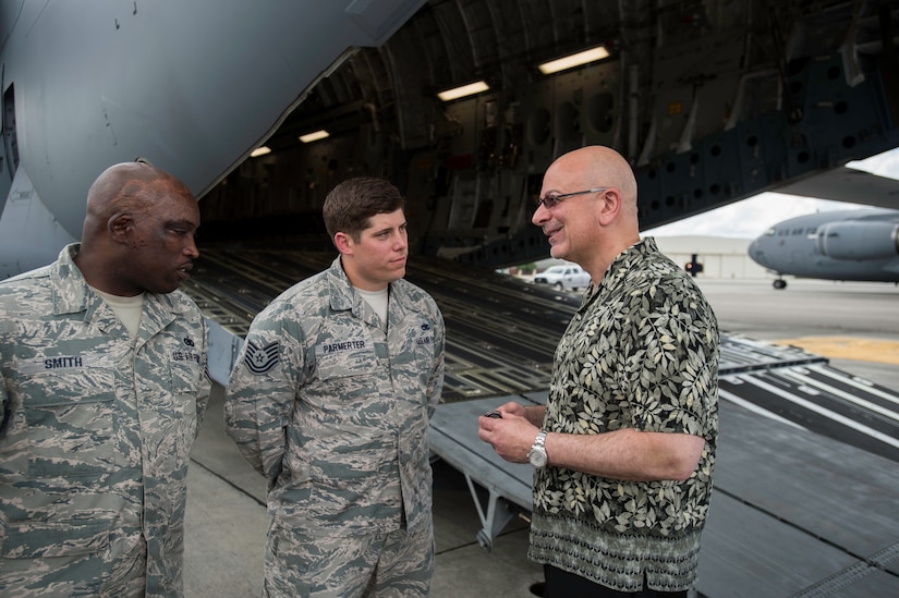 John Johns, deputy assistant secretary of defense for maintenance, presents a commemorative coin to Tech. Sgt. Brain Parmerter and Tech. Sgt. Richard Smith, for outstanding support June 4, 2015 at Joint Base Charleston, S.C. Johns was visiting Charleston to thank Airmen for their service. He provides oversight to the Department of Defense’s annual $80 billion maintenance program. Parmerter is a member of the 437th Aircraft Maintenance Squadron and Smith is a member of the 628th Logistics Readiness Squadron. (U.S. Air Force photo/Senior Airman Jared Trimarchi)  