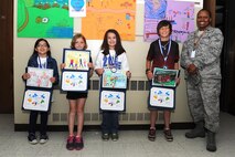 Students from Dakota Elementary School pose with their medals and certificates they earned for being selected for the People’s Choice Award at Minot Air Force Base, N.D., June 2, 2015. The students created a picture highlighting themselves enjoying something with their family and their pictures earned the most votes. (U.S. Air Force photo/Senior Airman Kristoffer Kaubisch)
