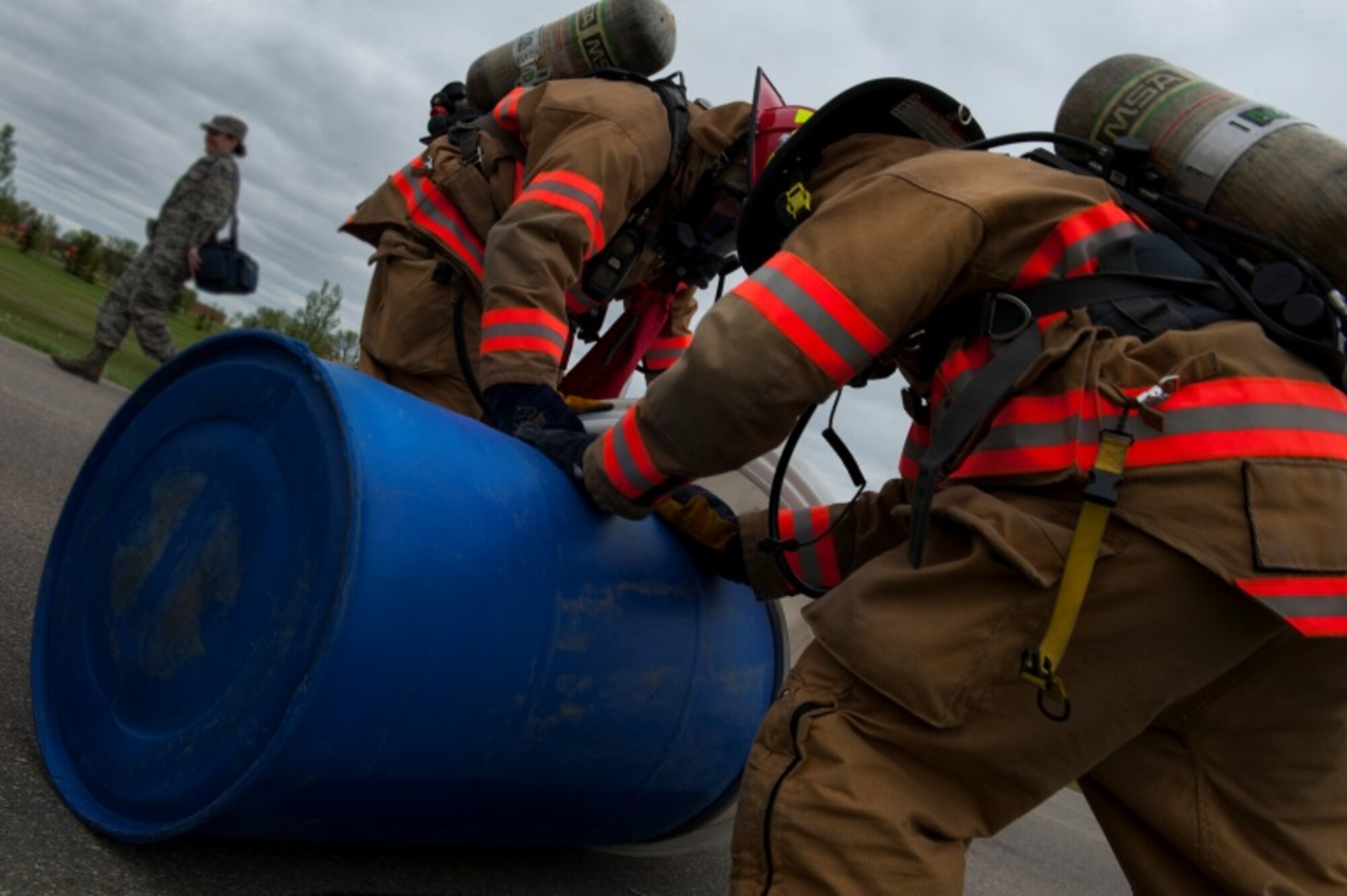 Members of the 5th Civil Engineer Squadron seal a barrel to prevent more leakage during an exercise at Minot Air Force Base, N.D., May 29, 2015. The exercise was held to ensure first responders and base personnel are properly trained to clean up and decontaminate a potential hazardous material situation. (U.S. Air Force photo/Airman 1st Class Christian Sullivan)