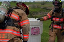 Members of the 5th Civil Engineer Squadron prepare to place a barrel leaking simulated hazardous material into another barrel to prevent any further harm during an exercise at Minot Air Force Base, N.D., May 29, 2015. The exercise tested the timeliness and efficiency of first responders in a simulated hazardous material situation. (U.S. Air Force photo/Airman 1st Class Christian Sullivan)