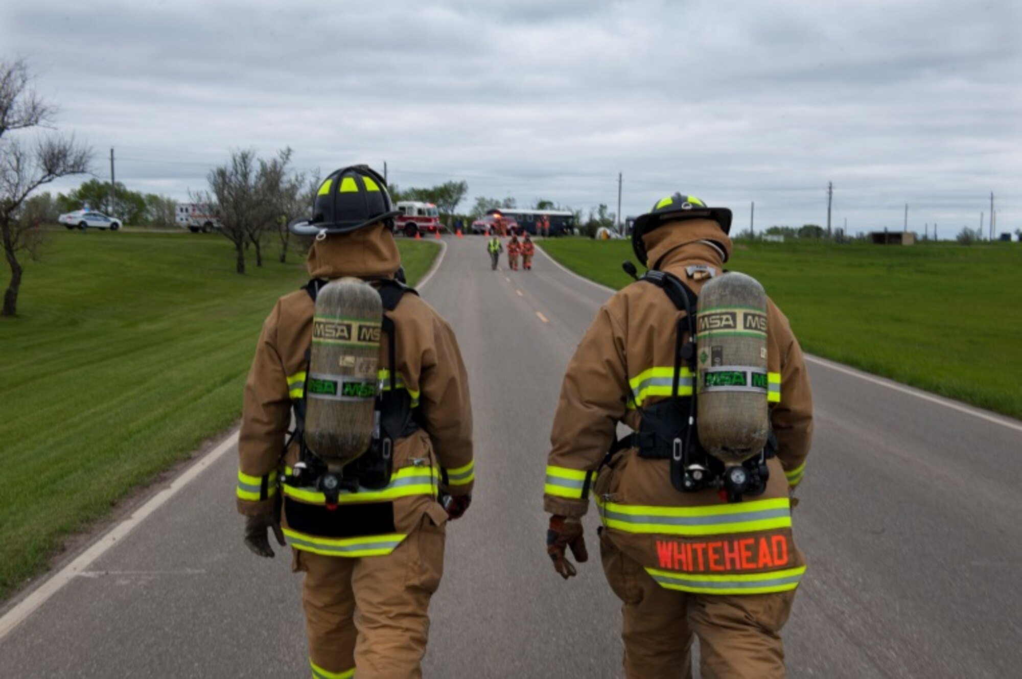 Two members of the 5th Civil Engineer Squadron, leave the scene of a simulated hazardous material spill during Exercise Prairie Rampart 15-2 at Minot Air Force Base, N.D., May 29, 2015. The exercise was held to ensure first responders and base personnel are properly trained to clean up and decontaminate a hazardous material situation. (U.S. Air Force photo/Airman 1st Class Christian Sullivan)