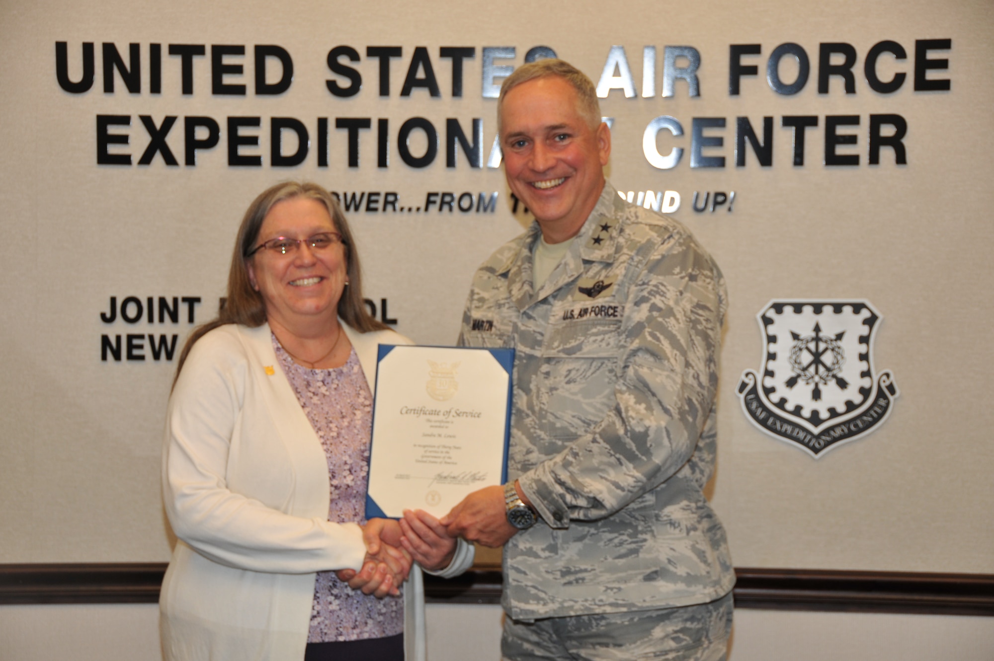 Sandy Lewis, U.S. Air Force Expeditionary Center budget technician, poses for a photo with Maj. Gen. Rick Martin, USAF EC commander, after receiving a pin and certificate for 30 years of federal service April 30. (U.S. Air Force photo/Brad Camara)
