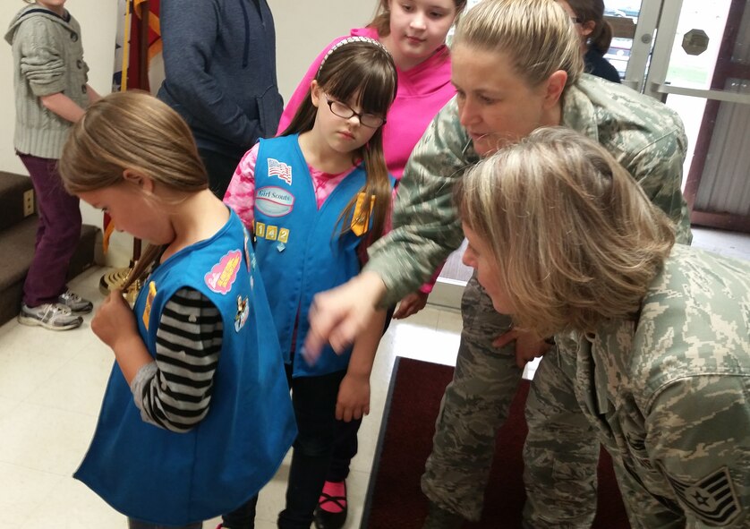 Col. Bobbi Doorenbos, 188th Wing commander, and Tech. Sgt. Karen Fletcher, 188th Logistics and Readiness Squadron member, look at a vest worn by a member of the Mansfield Girl Scout troop in Mansfield, Ark., April 27, 2015. Airmen with the 188th visited the troop to speak about opportunities in the Air National Guard. (U.S. Air National Guard photo by Staff Sgt.Jennifer Burgos/Released)