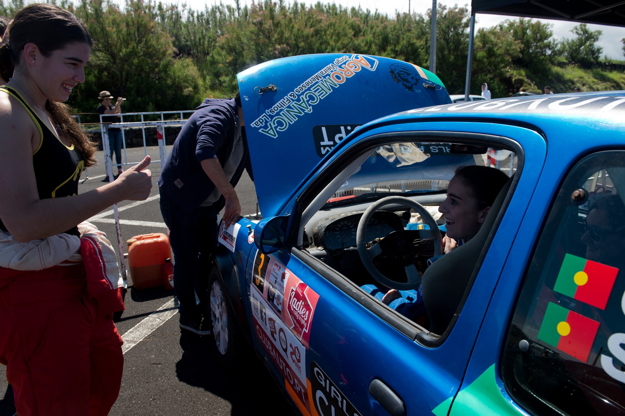 Senior Airman Alanna Britton, 65th Air Base Wing general law paralegal, talks to the driver of the number four car during a Ladies Rally race in Vila Nova, Azores, Portugal, May 30, 2015. Britton drove the triple zero car that is designated as the safety vehicle to ensure all potential hazards on the course are reported back to racers. (U.S. Air Force photo/Tech. Sgt. Zachary Wolf)(Released)