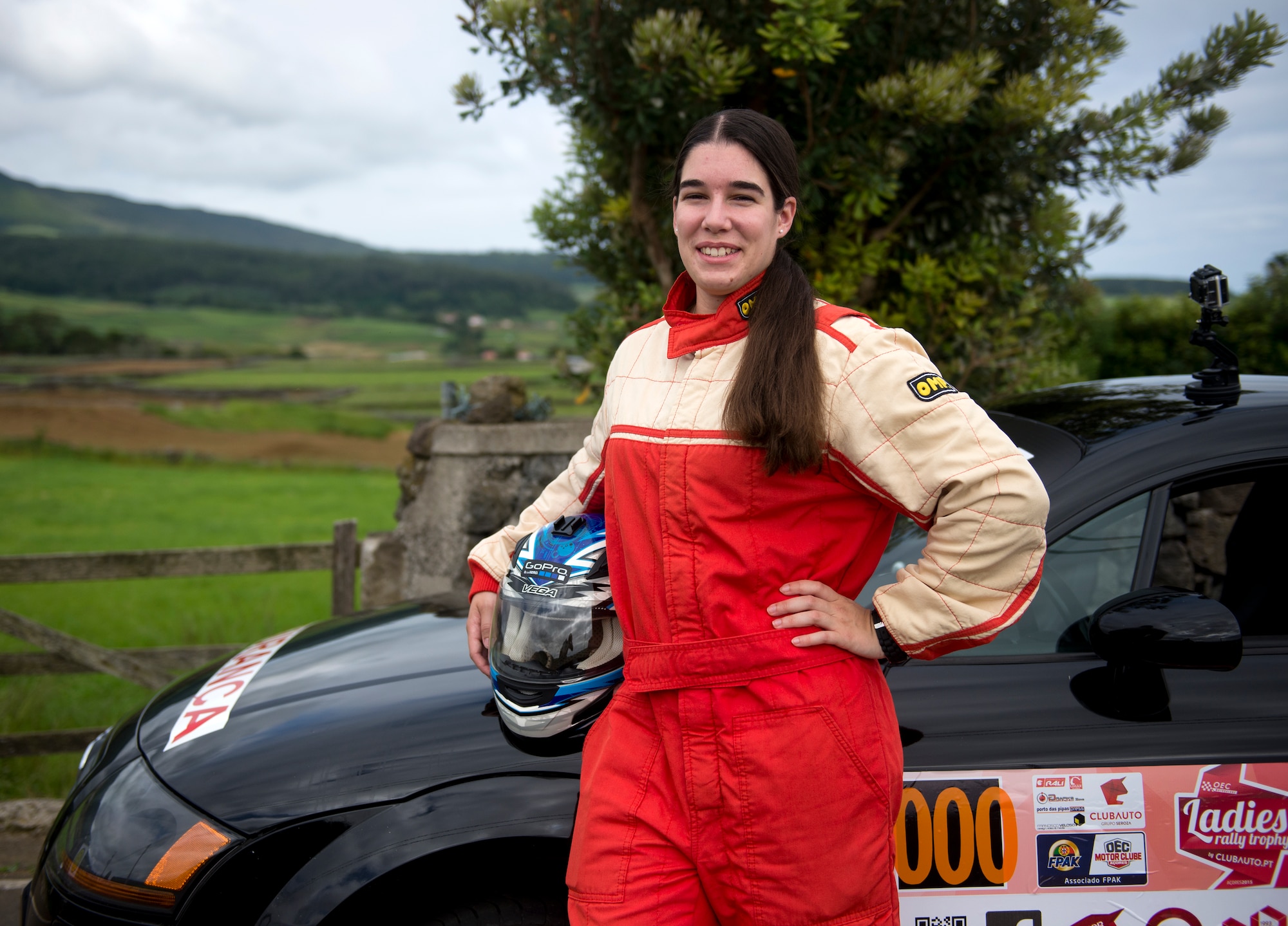 Senior Airman Alanna Britton, 65th Air Base Wing general law paralegal, poses next to her car during a Ladies Rally race in Vila Nova, Azores, Portugal, May 30, 2015. Britton drove the triple zero car that is designated as the safety vehicle to ensure all potential hazards on the course are reported back to racers. (U.S. Air Force photo/Tech. Sgt. Zachary Wolf)(Released)