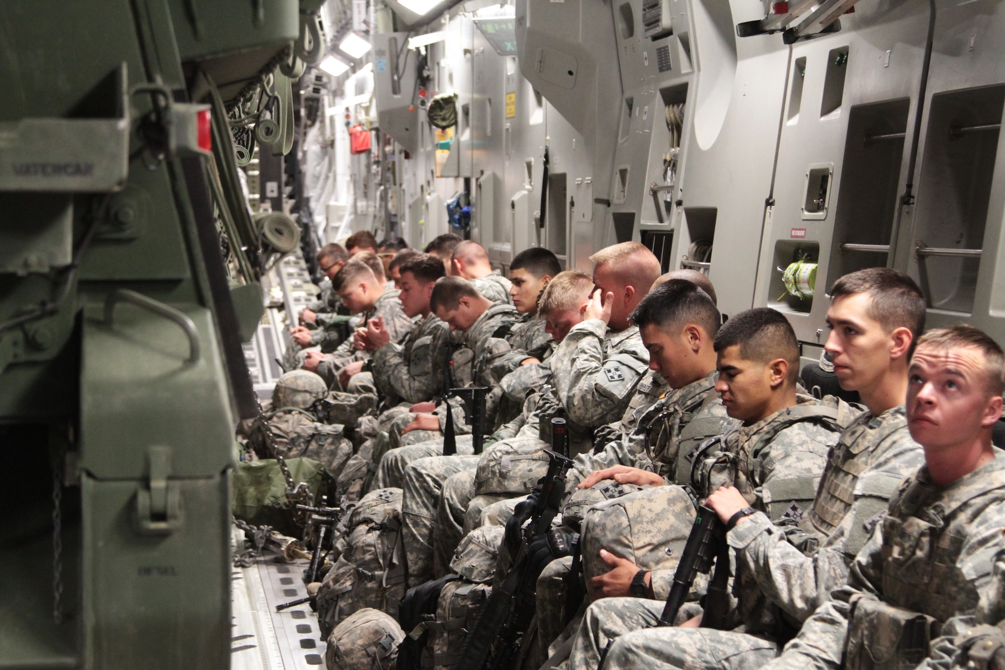 Soldiers of 2nd Battalion, 23rd Infantry Regiment, 1st Stryker Brigade Combat Team, 4th Infantry Division, prepare for their flight on a C-17 Globemaster III to the National Training Center in Fort Irwin, Calif., with their Strykers chained down in front of them, May 21, 2015.  The jet is known for being able to rapidly deploy troops and cargo all over the world but this validation exercise confirmed the ???Raider??? brigade???s ability to extend the range of any Colorado based Stryker unit.