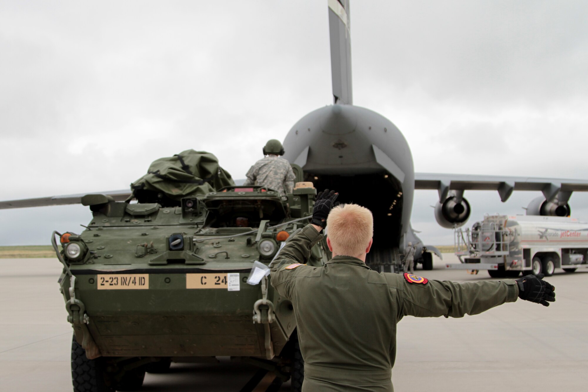 Airman 1st Class Brendon Markham, load master, 21st Airlift Squadron, ground guides a Stryker from 2nd Battalion, 23rd Infantry Regiment, 1st Stryker Brigade Combat Team, 4th Infantry Division, during air load operations in preparation for a flight to the National Training Center at Fort Irwin, Calif., May 21, 2015. ???We???re creating the standard operating procedures and relationships that are going to make us successful for when we might need to rapidly deploy,??? said Capt. Trey Van Whye, current operations planner, 1st SBCT, 4th Inf. Div.
