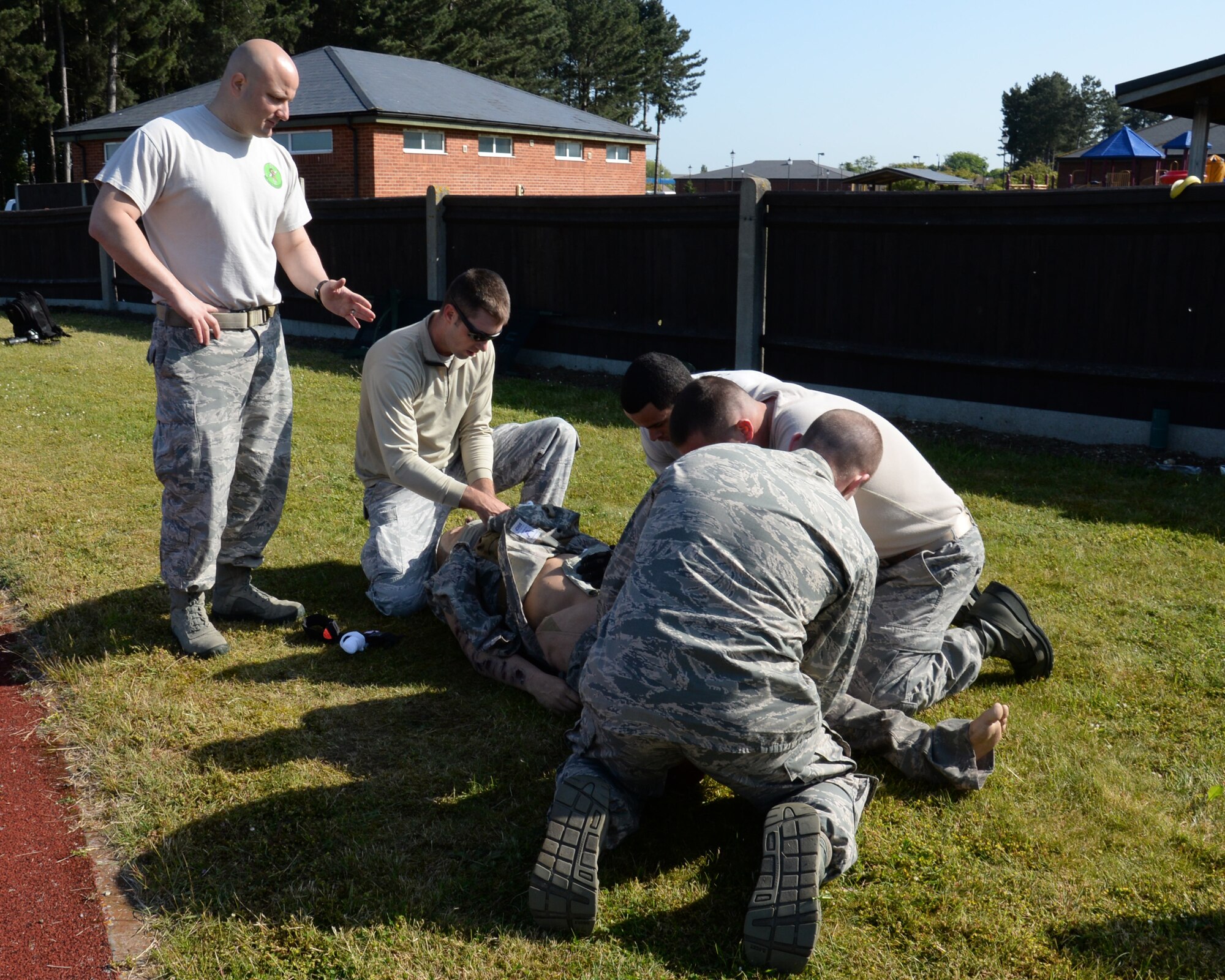 U.S. Air Force Tech. Sgt. Eduardo Clemente, left, 352nd Special Operations Support Squadron independent duty medical technician from Dothan, Ala., instructs a group of defenders taking part in a Self-Aid Buddy Care challenge during a “Defender Challenge” May 21, 2015, on RAF Mildenhall, England. During the challenge participants completed pushups and burpees then simulated SABC on a mannequin, testing their ability to perform while mentally and physically fatigued. (U.S. Air Force photo by Gina Randall/Released)