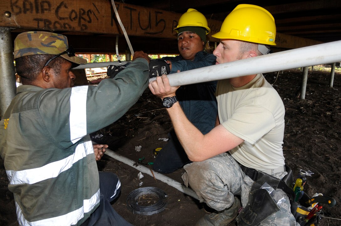 Papua New Guinea Defence Force plumbers and U.S. Air Force Nevada Air National Guard Staff Sgt. Alex Peden, 152nd Civil Engineering Squadron water and fuels system maintainer, install plumbing for a science lab during Pacific Angel 15-4 at Gahuku Primary School in the Eastern Highlands Providence, Papua New Guinea, June 2, 2015. Efforts undertaken during Pacific Angel help multilateral militaries in the Pacific improve and build relationships across a wide spectrum of civic operations, which bolsters each nation???s capacity to respond and support future humanitarian assistance and disaster relief operations. (U.S. Air Force photo by Staff Sgt. Marcus Morris/Released)