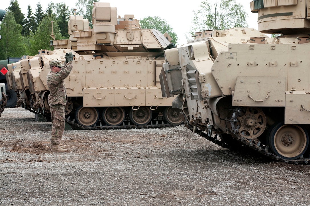 U.S. Army Sgt. Yasmani Reyes directs an M2A3 Bradley Fighting Vehicle ...