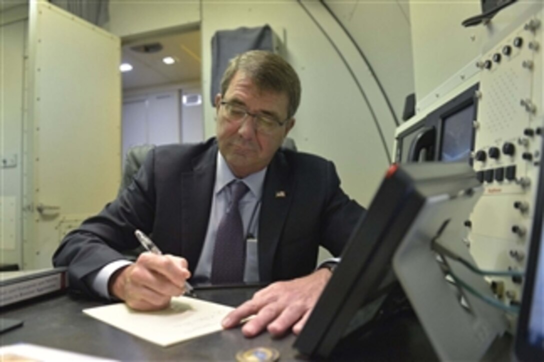 Seated in his cabin on an E4-B aircraft, U.S. Defense Secretary Ash Carter writes thank you letters to his hosts as he departs India following a two-day visit to meet with senior government and defense officials in New Delhi, June 4, 2015.  