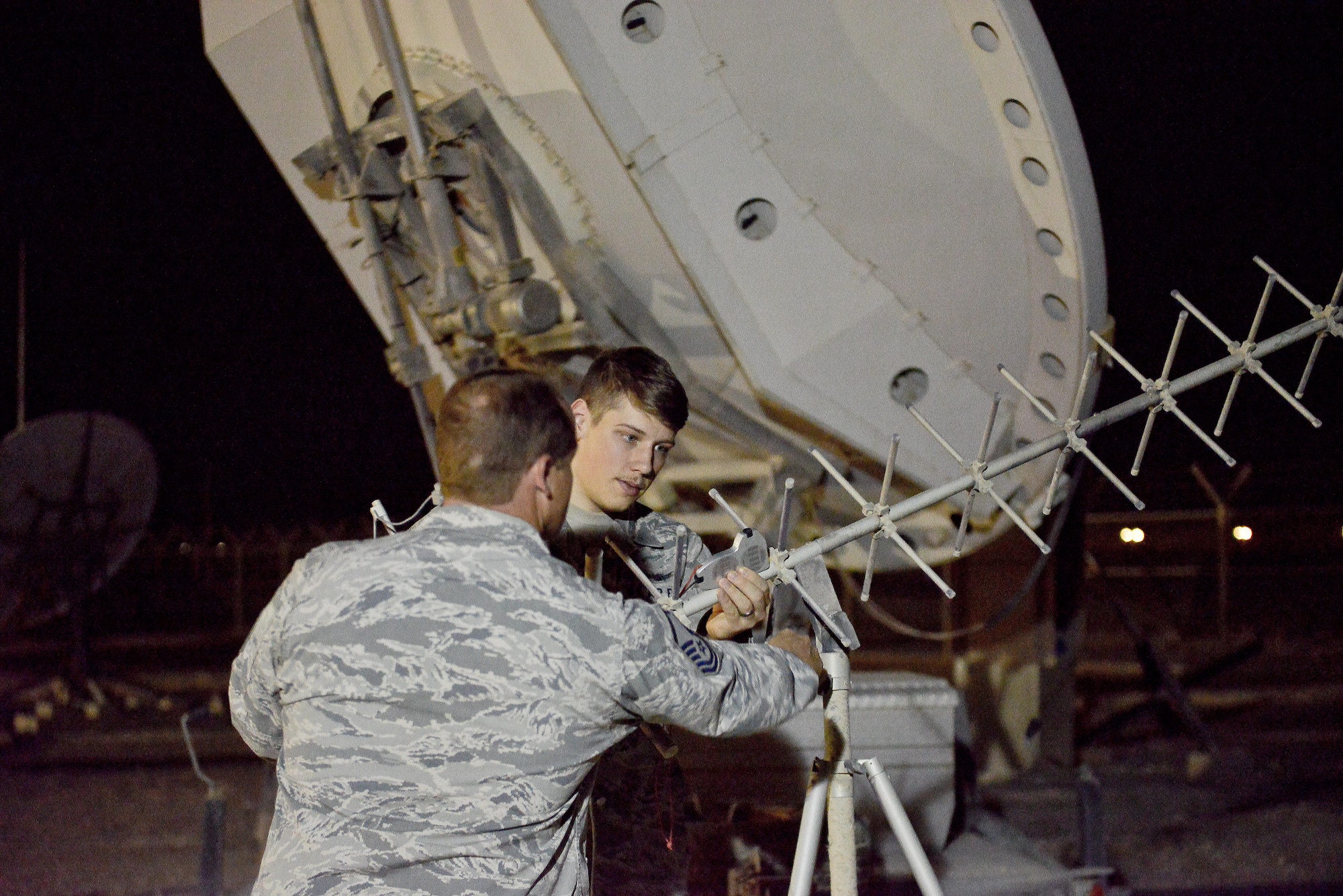 Master Sgt. Brian Popham and Senior Airman Casey Jones, 379th Expeditionary Operations Support Squadron Silent Sentry, calibrate an antenna’s height to correct a signal May 27, 2015 at Al Udeid Air Base, Qatar. The Silent Sentry team monitors high priority satellite communication signals, detects electromagnetic interference on those signals and geolocates the source of that interference along with other signals of interest. (U.S. Air Force photo/Staff Sgt. Alexandre Montes)