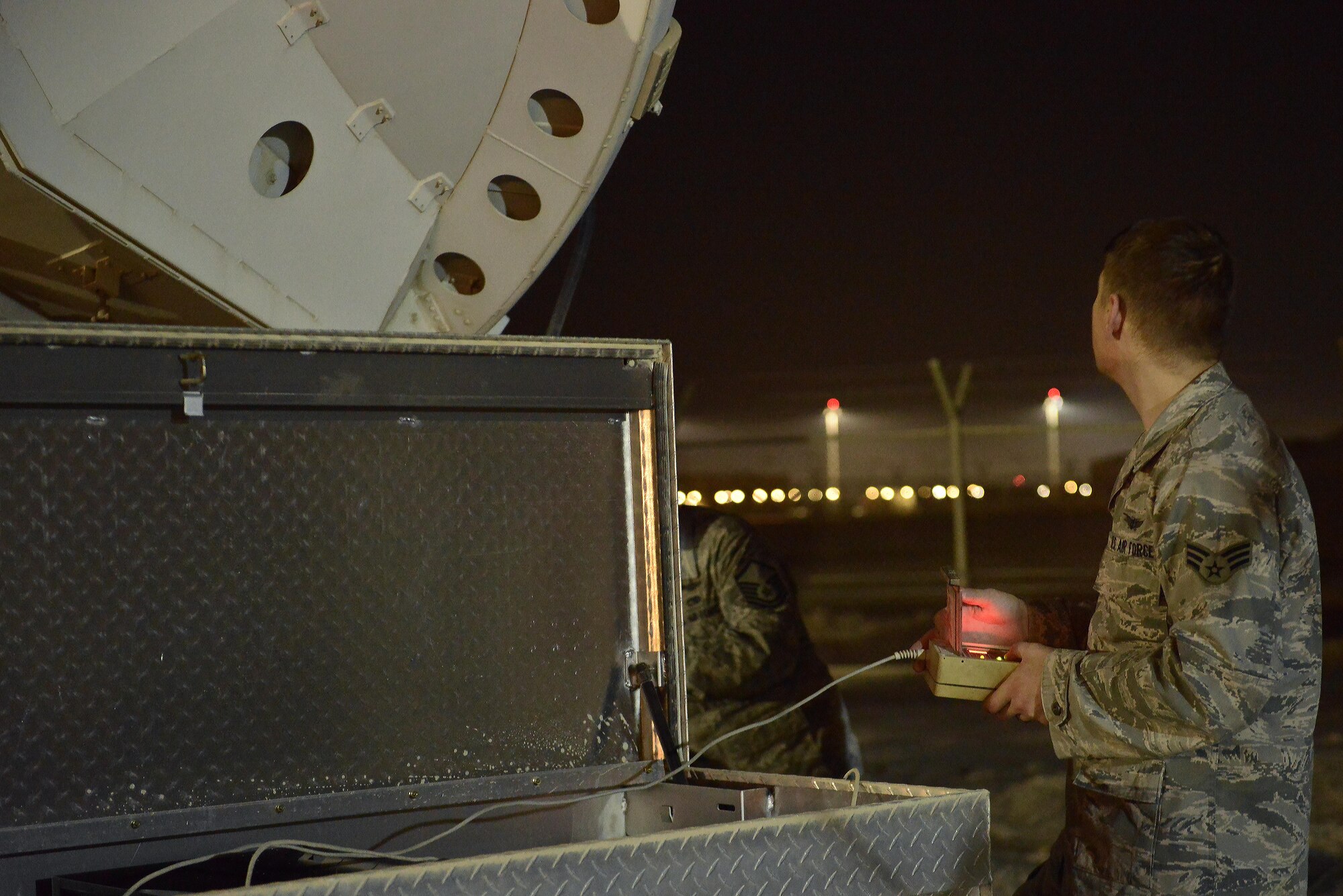 Senior Airman Casey Jones, 379th Expeditionary Operations Support Squadron Silent Sentry, uses a remote control to test the movement of an antenna that communicates to orbiting satellite May 27, 2015 at Al Udeid Air Base, Qatar. The Silent Sentry team monitors high priority satellite communication signals, detects electromagnetic interference on those signals and geolocates the source of that interference along with other signals of interest. (U.S. Air Force photo/Staff Sgt. Alexandre Montes)