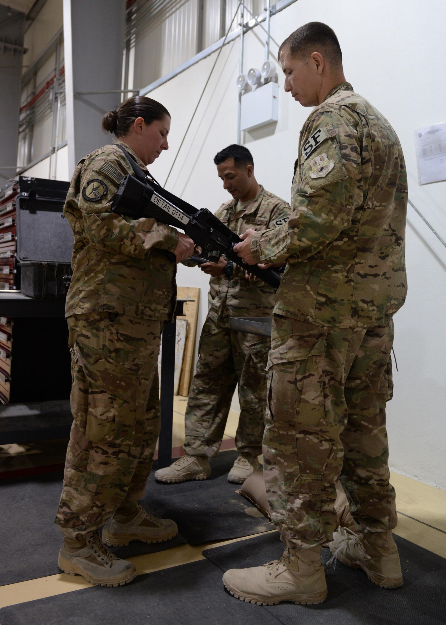 U.S. Air Force Master Sgt. Joseph Reyes, 455th Expeditionary Security Forces Squadron intel anti-terrorism representative and alternate Check 6 program manager, helps an Airmen clear out a weapon before starting hands on Check 6 weapons retention May 25, 2015, at Bagram Air Field, Afghanistan. Check 6 is an active shooter/insider threat awareness program that teaches Airmen how to react and respond with their weapons in the event that a hostile situation occurs at the base. (U.S. Air Force photo by Senior Airman Cierra Presentado/Released)