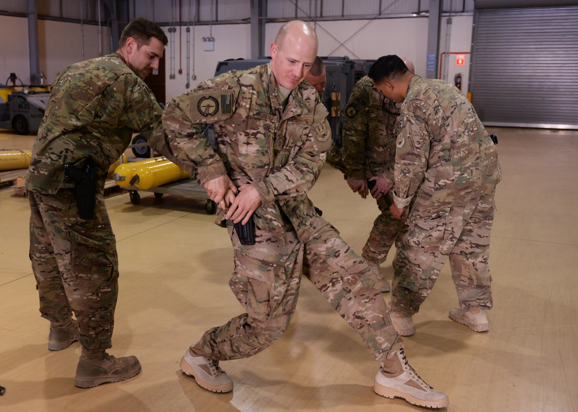 U.S. Airmen practice weapons retention during Check 6 training May 25, 2015, at Bagram Air Field, Afghanistan. Check 6 is a mandatory program for all BAF Airmen and includes training on how to react and respond to an active shooter/insider threat, as well as how to perform as a team in the event a hostile situation should occur at the base. (U.S. Air Force photo by Senior Airman Cierra Presentado/Released)