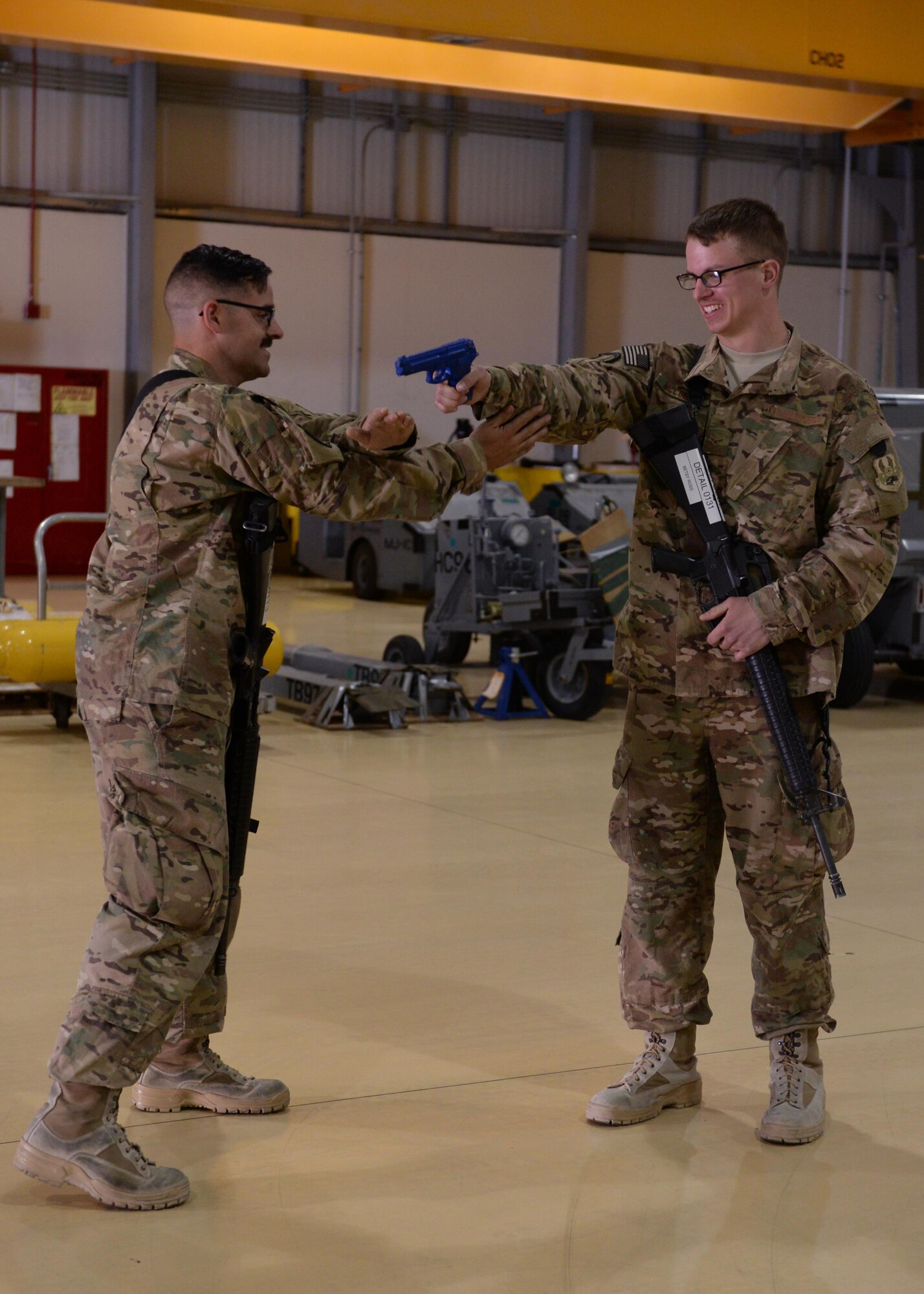 Two U.S. Airmen demonstrate their newly learned skills on weapons retention during Check 6 training May 25, 2015, at Bagram Air Field, Afghanistan. Check 6 is a mandatory program for all BAF Airmen and includes training on how to react and respond to an active shooter/insider threat as well as how to perform as a team in the event a hostile situation should occur at the base. (U.S. Air Force photo by Senior Airman Cierra Presentado/Released)
