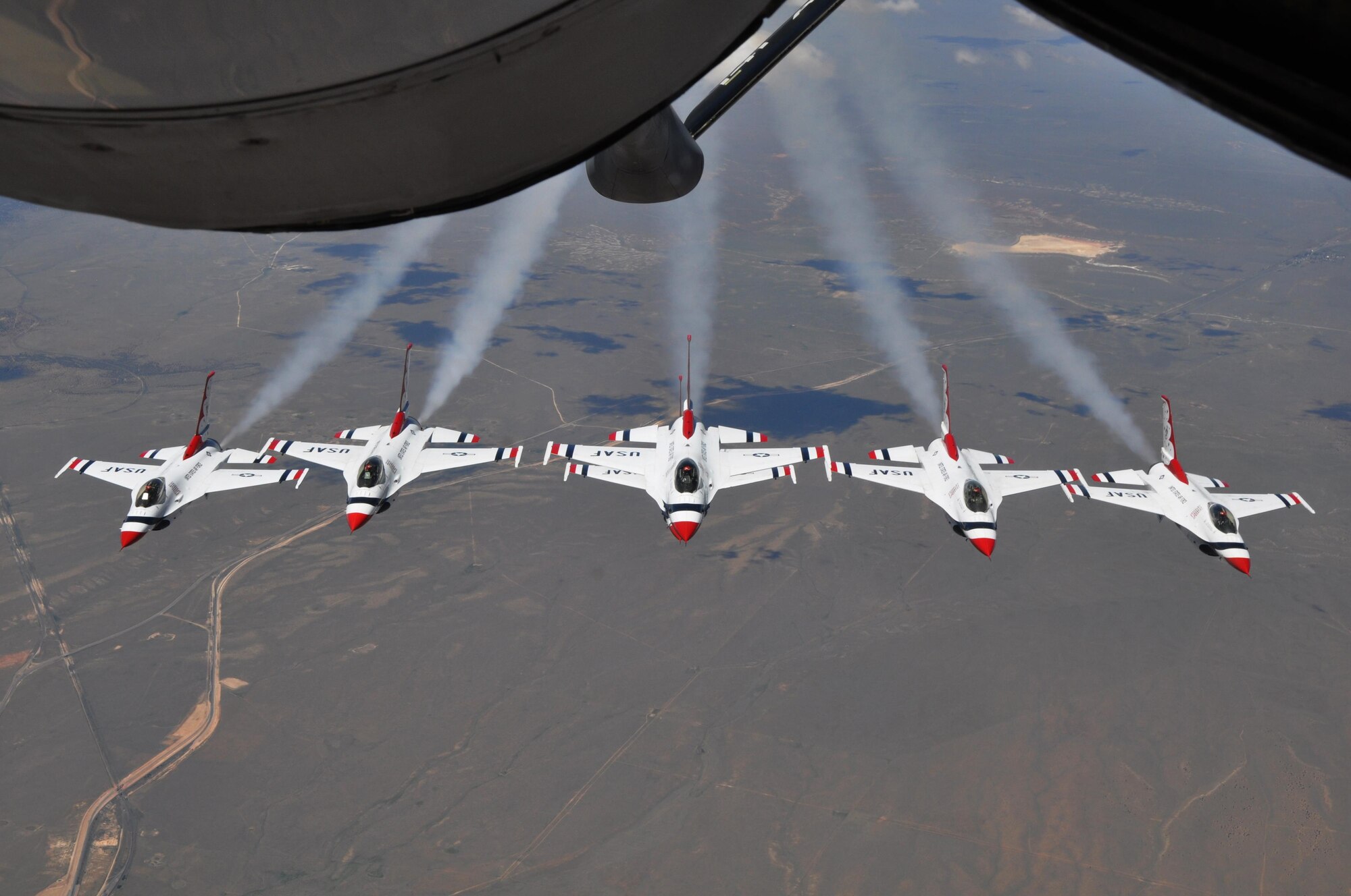 The U.S. Air Force Thunderbirds Air Demonstration Squadron, fly their F-16 Fighting Falcons into formation near the refueling boom of a KC-135 Stratotanker from McConnell Air Force Base, Kan., June 4, 2015. The KC-135 provided cross-country air refueling support for the Thunderbirds. The KC-135 aircrew, all Air Force Reservists from the 931st Air Refueling Group, performed fourteen air refueling contacts during the mission. The squadron was on their way to the Heart of Texas Airshow in Waco, Texas, June 6-7. The squadron performs approximately 75 demonstrations each year and has never canceled a demonstration due to maintenance difficulty. More than 300 million people in all 50 states and 58 foreign countries have seen the red, white and blue jets in more than 4,000 aerial demonstrations. (U.S. Air Force photo by Tech. Sgt. Abigail Klein)