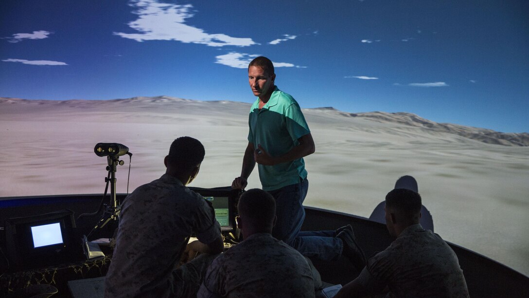 Greg Szczepaniak (center), a Supporting Arms Virtual Trainer operator, discusses emergency close air support procedures with squad leaders from Charlie Company, 1st Battalion, 8th Marine Regiment during training at the SAVT facility at Marine Corps Base Camp Lejeune, N.C., June 2, 2015. The training was conducted to ensure all of the squad leaders within the company are familiar with emergency CAS procedures so they can employ the tactics if the need arises while on deployment.