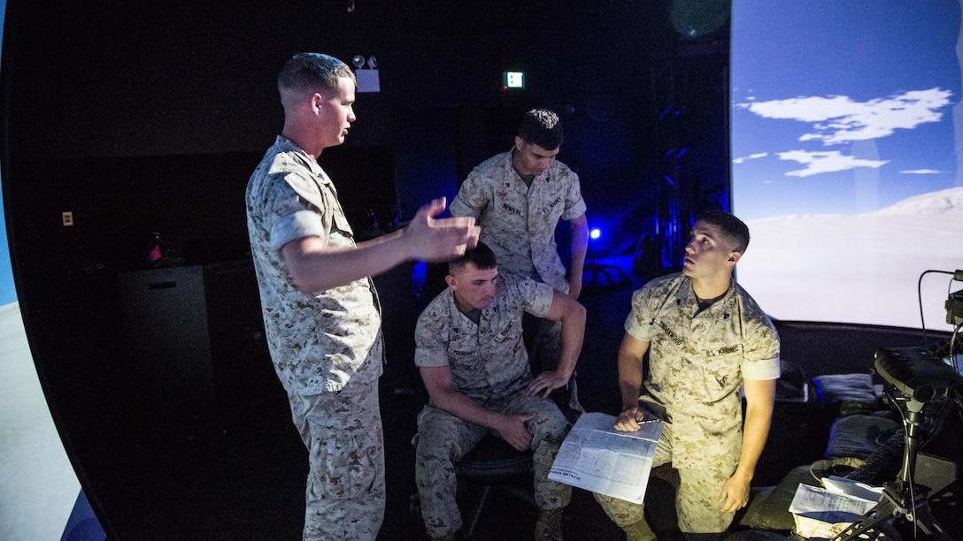 Sergeant Matthew Whitaker (left), a mortar section leader and joint fires observer with Charlie Company, 1st Battalion, 8th Marine Regiment, explains how to use different pieces of equipment with other squad leaders from the company during emergency close air support training at the Supporting Arms Virtual Trainer facility at Marine Corps Base Camp Lejeune, North Carolina, June 2, 2015. The training was conducted to ensure all of the squad leaders within the company are familiar with emergency CAS procedures so they can employ the tactics if the need arises while on deployment.