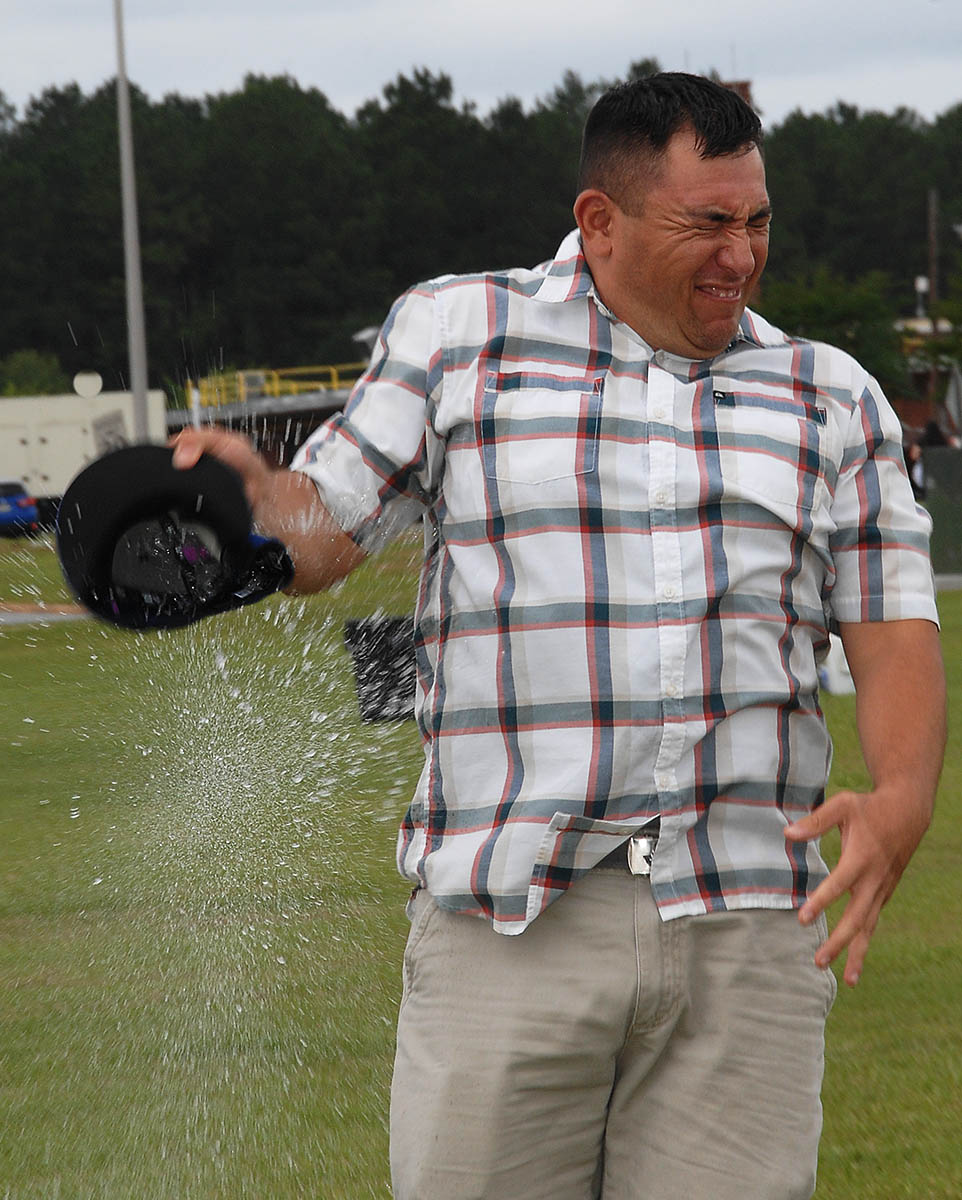 Gunnery Sgt. Joel Campos, provost sergeant, Marine Corps Police Department, Marine Corps Logistics Base Albany, flinches as a water balloon bursts in his hand during the Combined Unit and Family Fun Day at Covella Pond here, June 4.