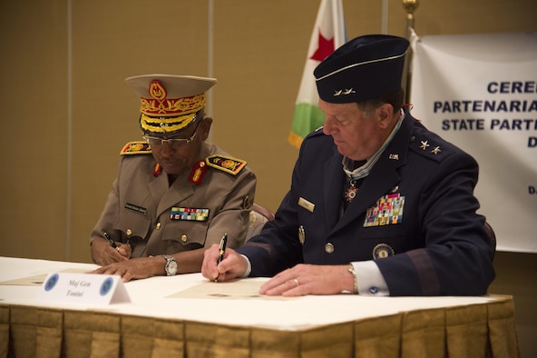 Maj. Gen. Zakaria Cheik Ibrahim, the Djiboutian Armed Forces (FAD) chief of defense, and Maj. Gen. Edward Tonini, the Kentucky National Guard (KNG) adjutant general, sign a State Partnership Program agreement at the Kempinski Hotel, Djibouti, June 2, 2015. The agreement means a long-term cooperative agreement between the KNG and FAD that will foster mutually beneficial exchanges between the two at all levels of the military as well as the civilian world. (U.S. Air Force photo/Staff Sgt. Nathan Maysonet)