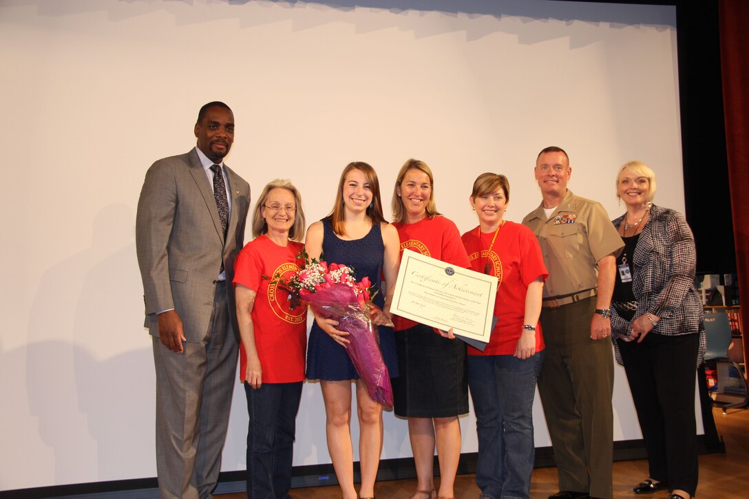 From the left, Adrian Talley, principal deputy director of DoDEA; Donna Kacmarski, principal at Crossroads Elementary School; Victoria Hansen, Mary's daughter; Mary Hansen, DoDEA Teacher of the Year and STEM teacher at Crossroads Elementary School; Tracey Fairfax, assistant principal at Crossroads Elementary School; Col. David Maxwell; and Helen Balilo, DoDEA New York/Virginia/Puerto Rico district assistant superintendant, stand together after Hansen received her award at Crossroads Elementary School on May 29.