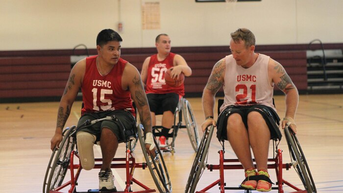 Cpl. Alex Nguyen (left), a native of Fremont, Nebraska, tries to maneuver past his defender, Staff Sgt. Phillip Shockley, a native of Scuffleton, North Carolina, during wheelchair basketball practice for the Marine team, Sept. 20, in preparation for the 2014 Warrior Games.  The Marine team is comprised of active duty and veteran wounded, ill and injured Marines who are attached to or supported by the Wounded Warrior Regiment, the official unit of the Marine Corps charged with providing comprehensive non-medical recovery care to wounded, ill and injured Marines. 