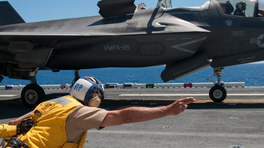 Vice Adm. William Hilrides, commander of Naval Sea Systems Command  takes the shooter stance while he launches an F-35B Lightning II off the flight deck of USS Wasp. Wasp, with VMFA-121 and VMFAT-501 embarked, is underway conducting the first phase of operational testing for the F-35B aircraft, which will evaluate the full spectrum of F-35B measures of suitability and effectiveness in an at-sea environment.