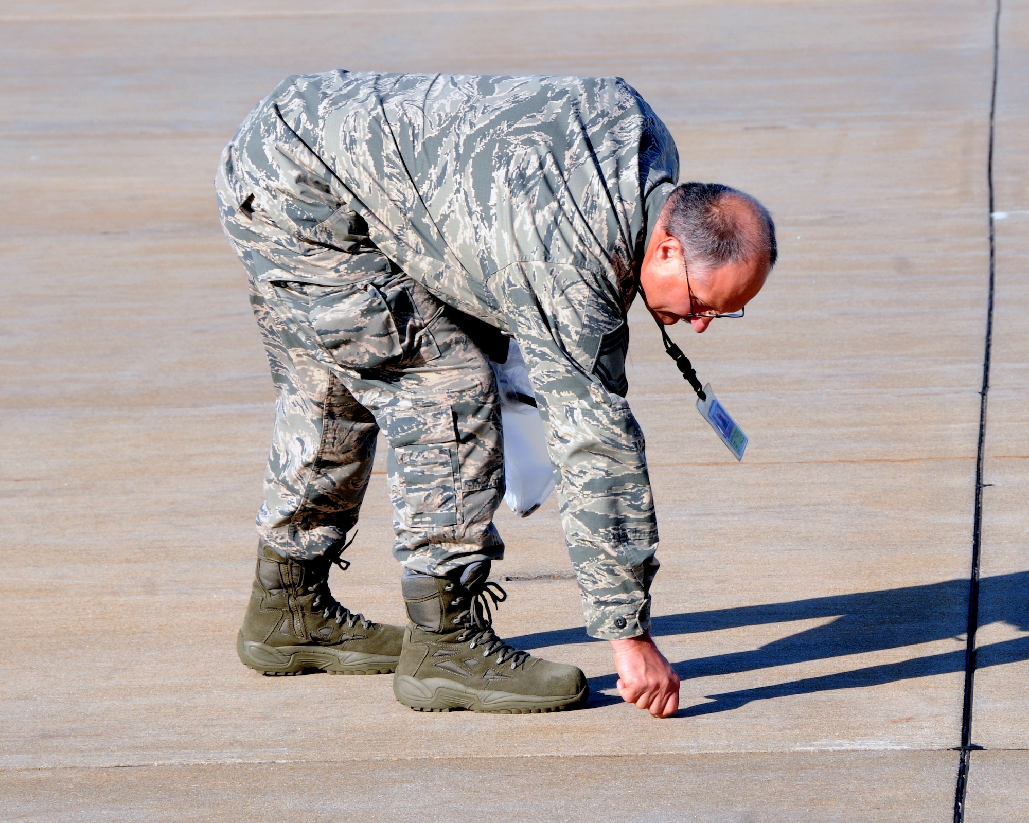 Air Force Reserve Chief Master Sgt. Paul Wagner, acting 910th Aircraft Maintenance Squadron superintendent, participates in a Foreign Object Damage (FOD) walk here, June 3, 2015. A FOD walk is done periodically on military installations to look for objects on the flight line that may damage aircraft. As incentive, a golden bolt was placed on the flight line before the FOD walk. The Airman who found the bolt during the walk was rewarded with a gift certificate. (U.S. Air Force photo/ Tech. Sgt. Rick Lisum)