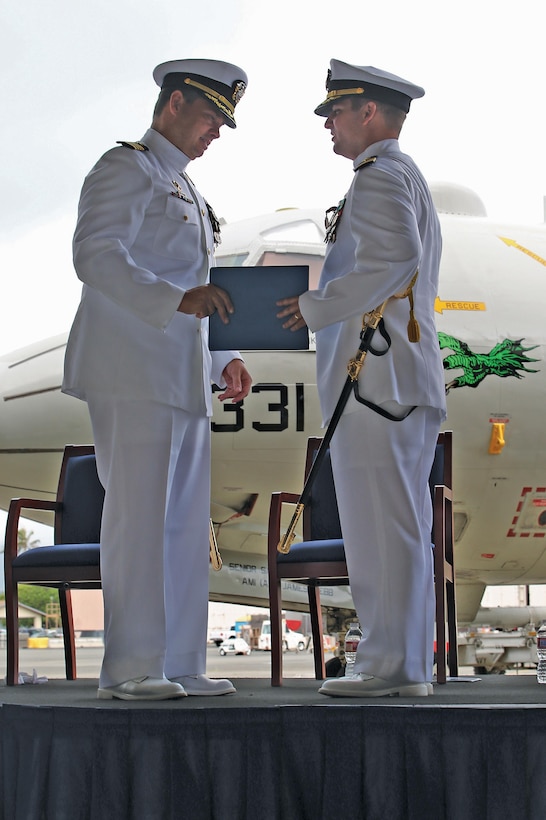 Cmdr. Eric M. Hanks, outgoing commanding officer for Patrol Squadron 4, recieves the Meritorious Service Medal from Capt. Steve L. Newlund, commander of and reconnaissance twin two. Cmdr. Hanks, relieved his duties onto Cmdr. Jonathan E. Spore.