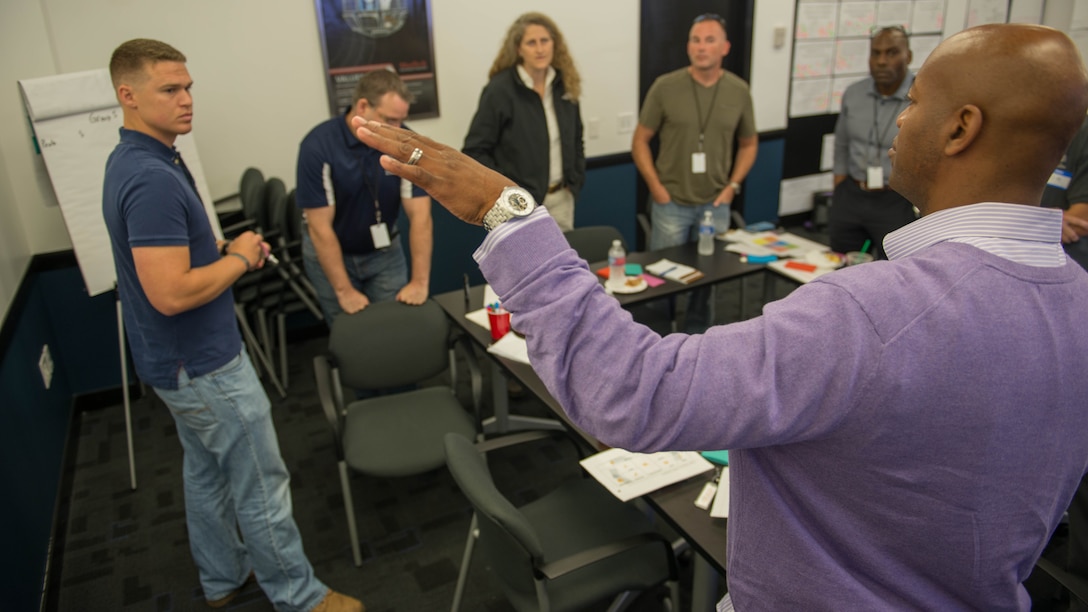 Master Sgt. Samuel Carter special intelligence system communicator, 3rd Radio Battalion III Marine Expeditionary Force, talks to his group about a possible solution for the problem statement they are discussing. The technical design meeting consists of Marines and civilians from different intelligence commands around the Marine Corps.