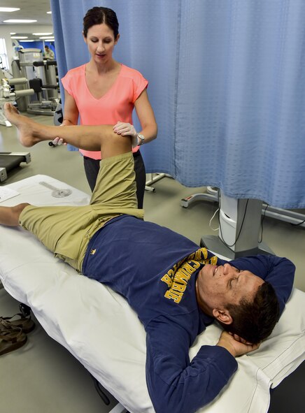 Dr. Jennifer Hedenschoug, 1st Special Operations Medical Operations Squadron physical therapist, performs a range of motion exercise on Tech. Sgt. Aaron Coste’s, 1st Special Operations Equipment Maintenance Squadron aerospace ground equipment technician, leg at the physical therapy clinic on Hurlburt Field, Fla., June 5, 2015. Physical therapy primarily focuses on the remediation of injuries and disabilities as well as the promotion of mobility, functional ability, quality of life and movement potential through examination, evaluation, diagnosis and physical intervention. (U.S. Air Force photo/Senior Airman Jeff Parkinson)

