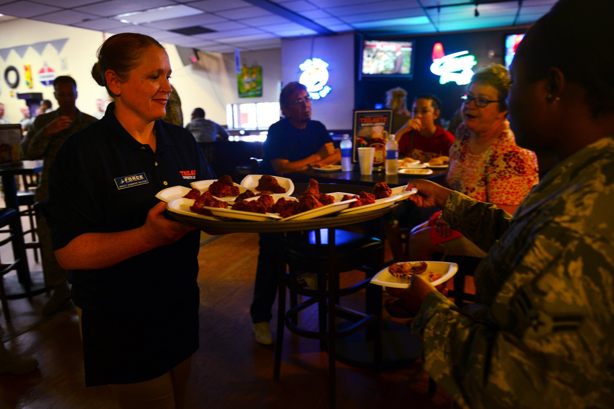 U.S. Air Force Senior Master Sgt. Jennifer Holton, 27th Special Operations Force Support Squadron military personnel flight superintendent, offers food samples to Air Commandos at the Drop Zone’s grand reopening June 4, 2015 at Cannon Air Force Base, N.M. The samples featured new menu items from the Tailgate Sports Lounge, the building’s new sit-down restaurant. (U.S. Air Force Photo/Airman 1st Class Shelby Kay-Fantozzi)
