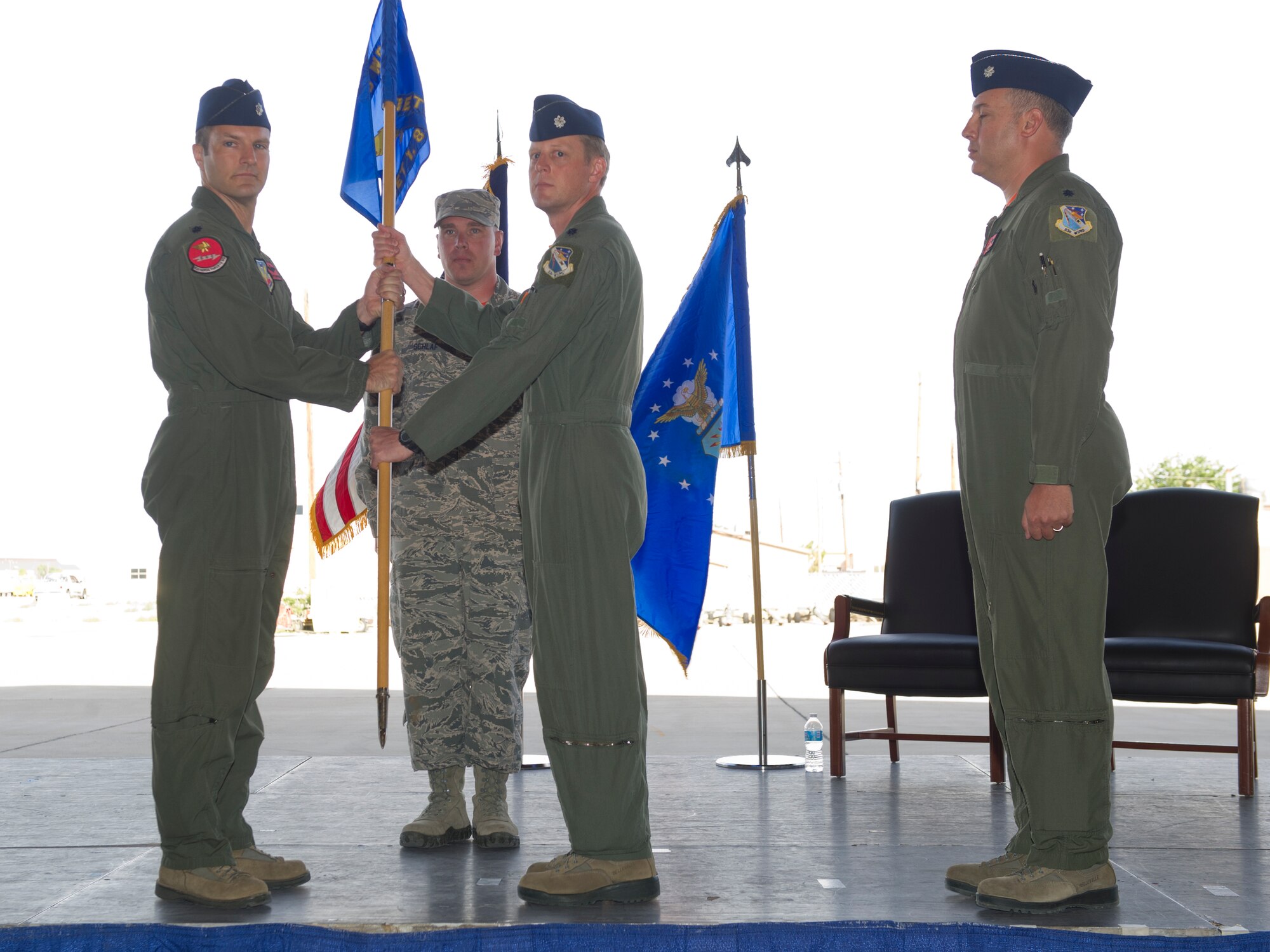 Lt. Col. Brian M. Swyt, the outgoing commander of Holloman’s Detachment 1, 82d Aerial Targets Squadron, passes the unit guidon to their parent unit commander, Lt. Col. Matthew Garrison, 82d ATRS commander from Tydell Air Force Base, Fl., symbolizing the seamless change of command at Holloman Air Force Base, N.M., June 5. In the ceremony Lt. Col. Ronald King assumed command of Det 1, 82d ATRS from Swyt. Det 1, 82nd Aerial Targets Squadron operates QF-4 and QF-16 full-scale aerial targets for use at the White Sands Missile Range.  (U.S. Air Force photo by Staff Sgt. Stacy Moless/Released)