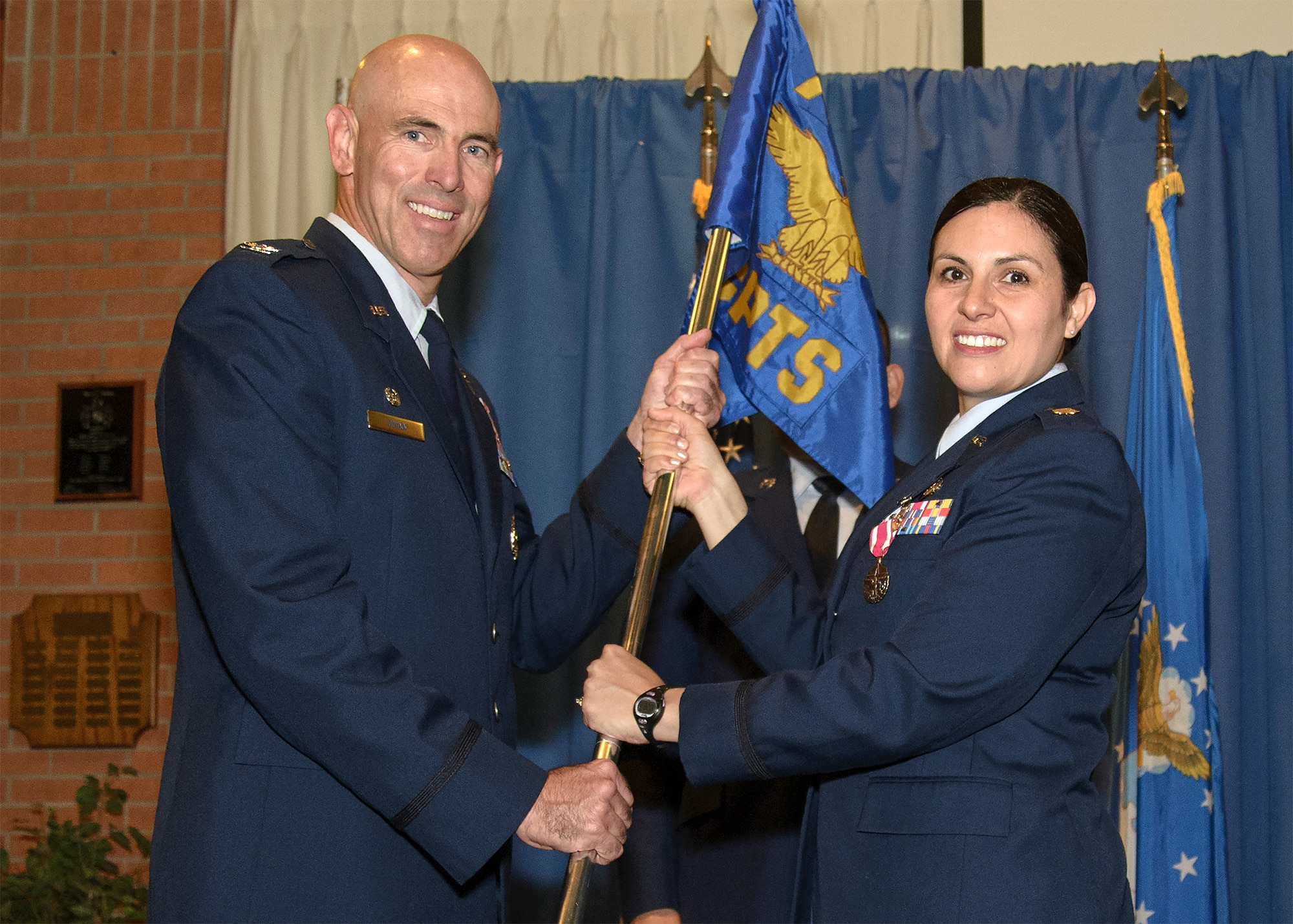 Maj. Dorinda Mazza passes the 71st Comptroller Squadron guidon to Col. Clark Quinn, the 71st Flying Training Wing commander, at Vance Air Force Base, Oklahoma, June 5. Mazza relinquished command of the squadron during a morning ceremony. (U.S. Air Force photo / David Poe)