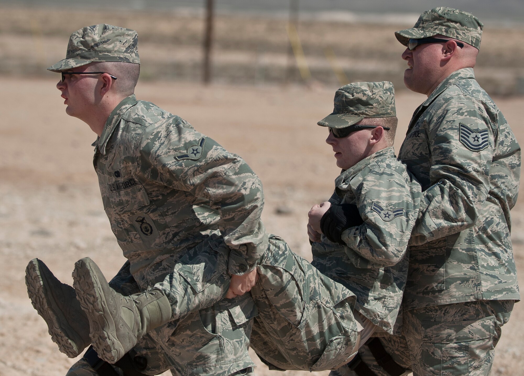 Participants in the Warrior Challenge perform a self-aid buddy care carry during the competition at Nellis Air Force Base, Nev., May 29, 2015. After completing the SABC carries, each team ruck marched one mile to the next exercise station. (U.S. Air Force photo by Staff Sgt. Siuta B. Ika)