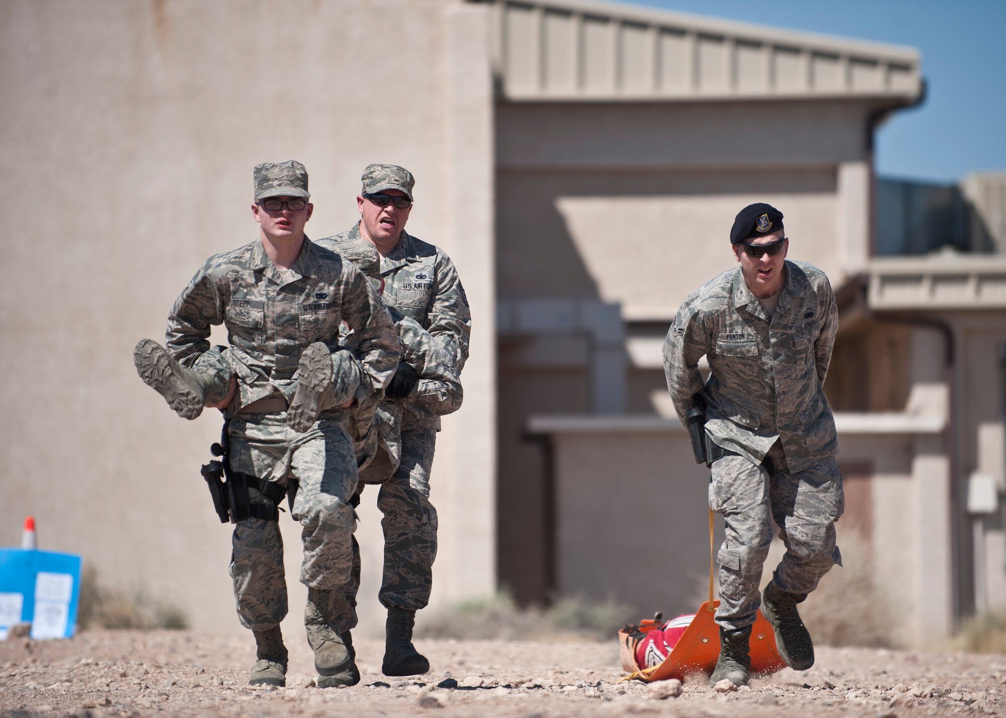 Participants in the Warrior Challenge perform self-aid buddy care carries during the contest at Nellis Air Force Base, Nev., May 29, 2015. During this portion of the competition, one team member pulled a 250-pound training dummy while two other members carried the fourth member who had a simulated leg-immobilizing injury. (U.S. Air Force photo by Staff Sgt. Siuta B. Ika)