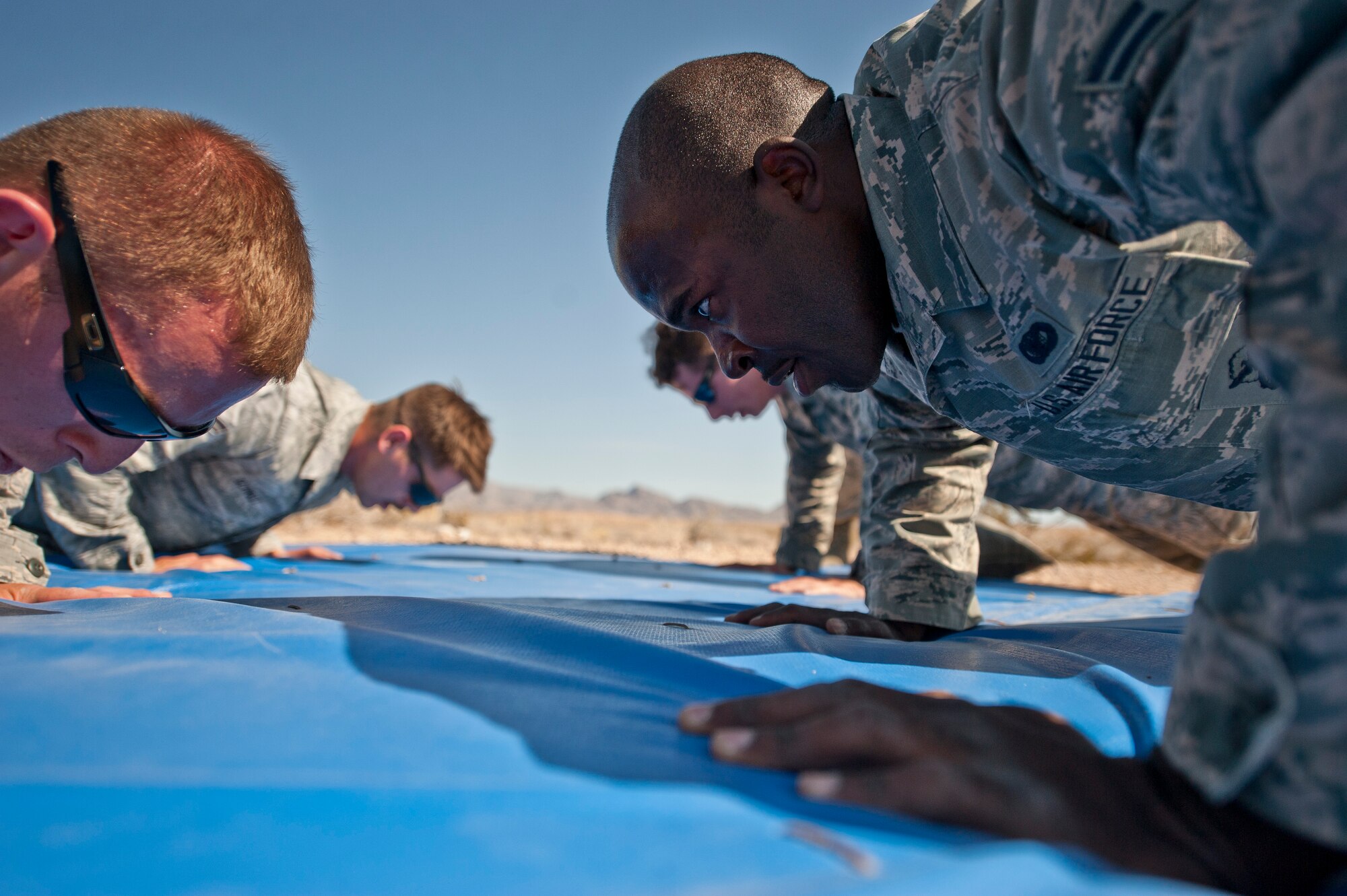 Participants in the Warrior Challenge perform pushups during the contest at Nellis Air Force Base, Nev., May 29, 2015. After completing the one-mile ruck march, each team had to collectively complete 400 pushups and situps. (U.S. Air Force photo by Staff Sgt. Siuta B. Ika)